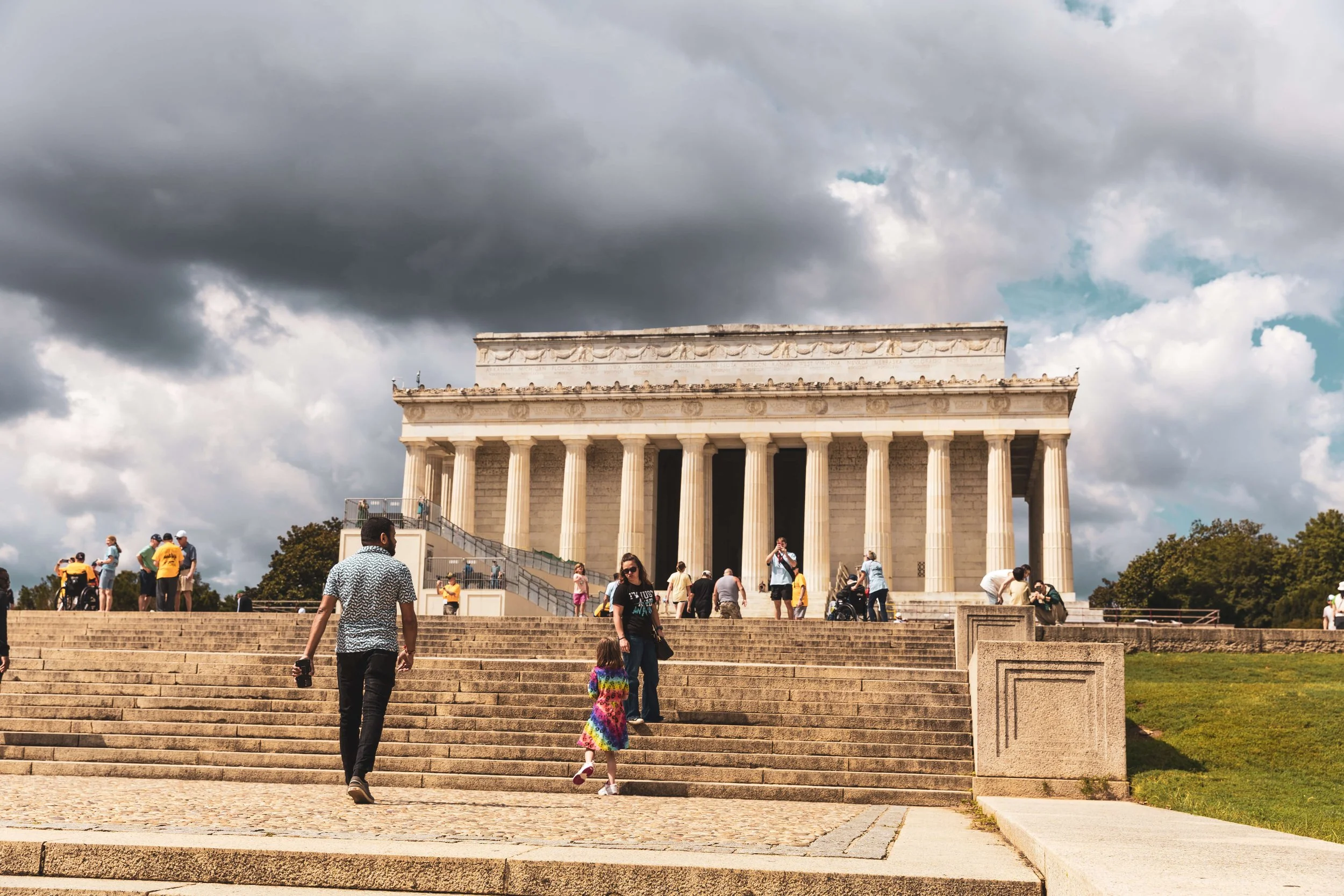 People visiting the Lincoln Memorial in Washington, D.C., on a partly cloudy day.