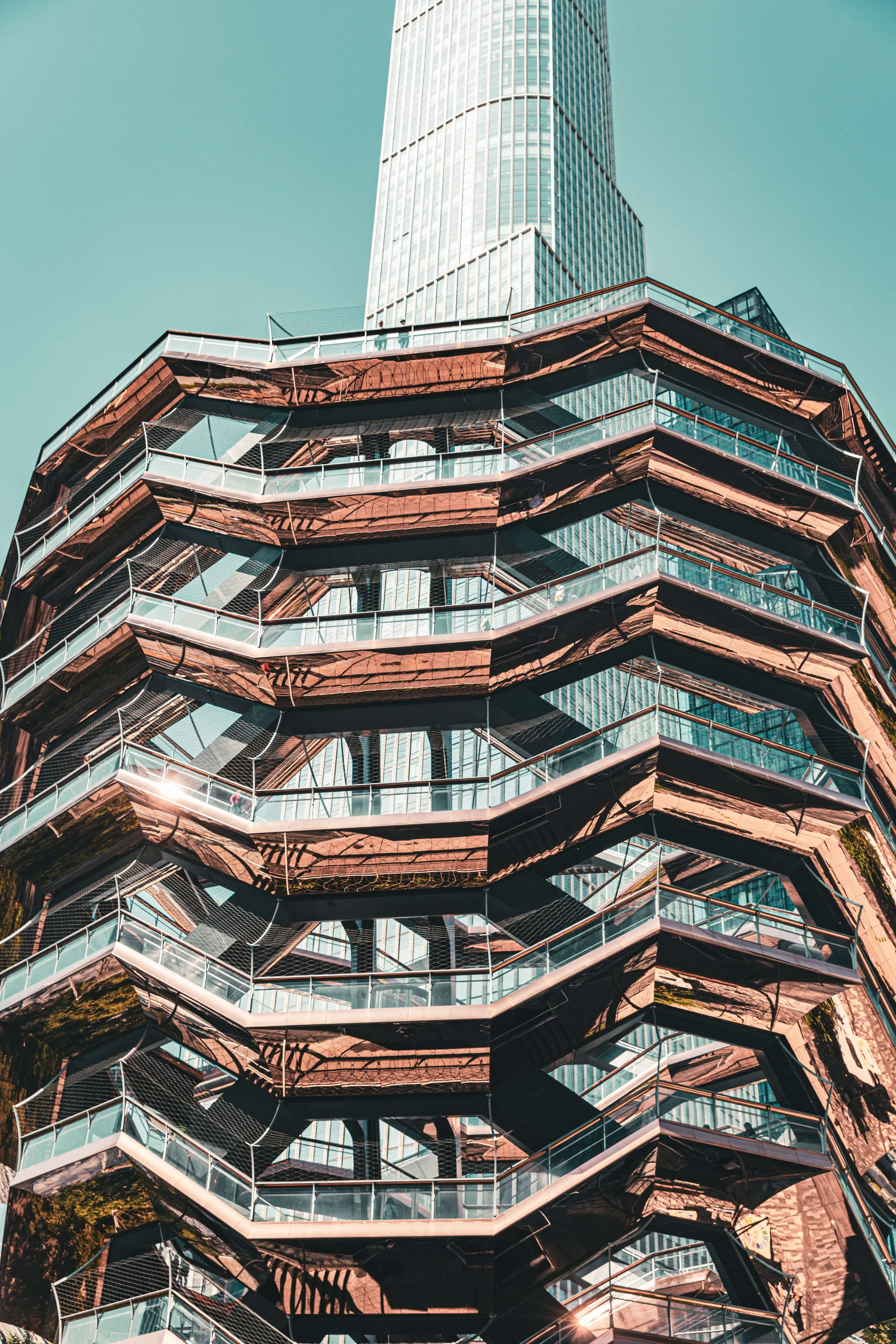 A modern high-rise building with reflective glass windows and a unique, layered architectural design.