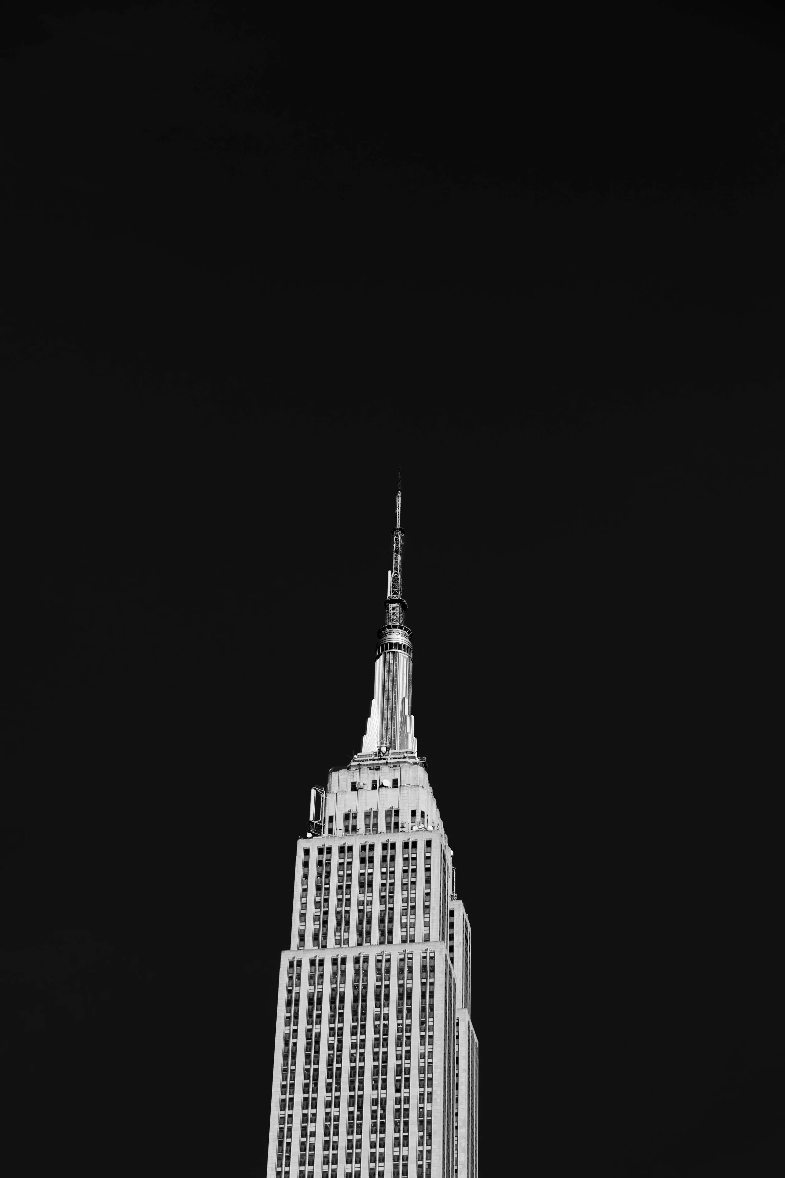 Black and white photo of the Empire State Building against a dark sky.