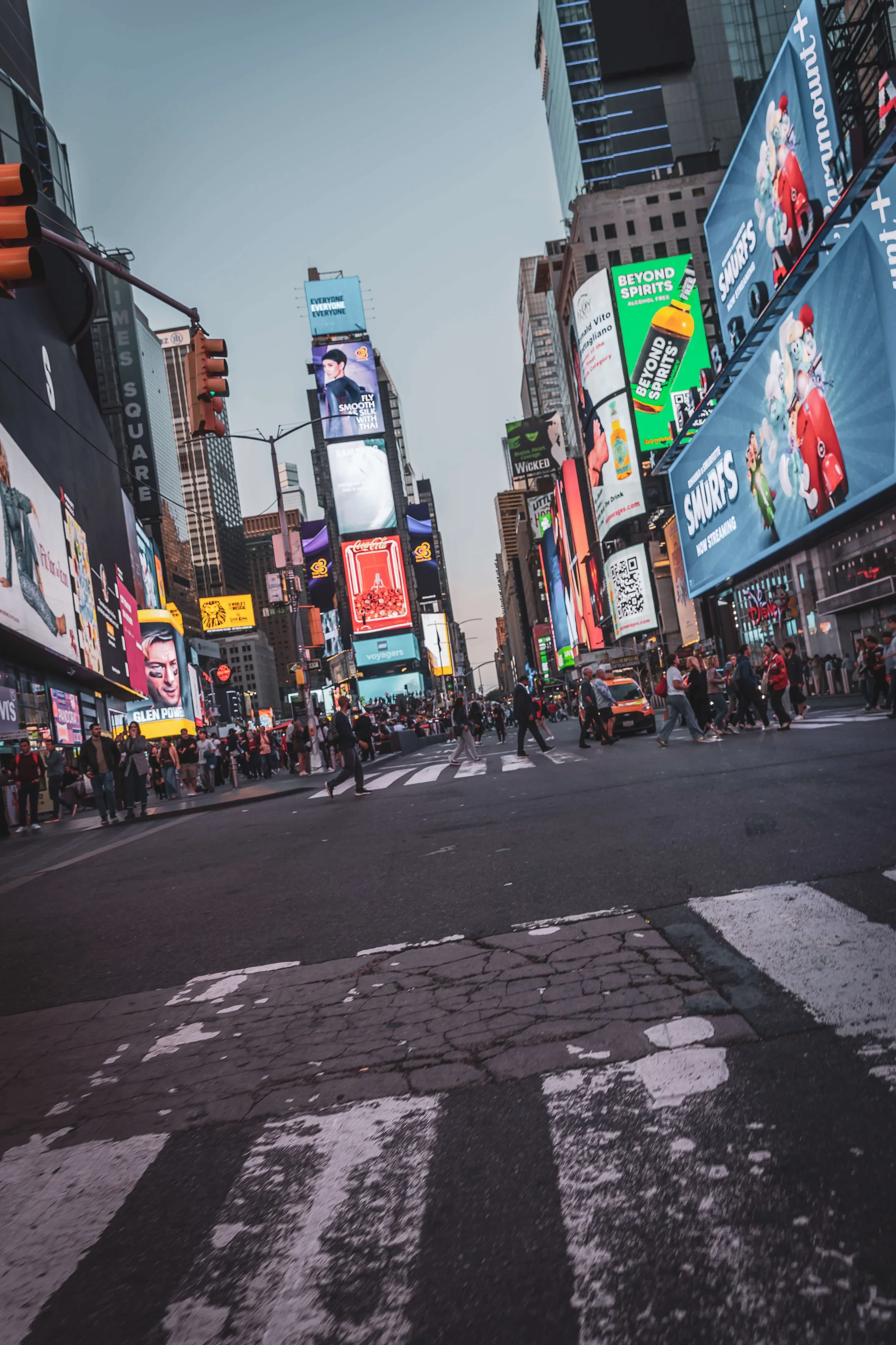 Busy seconds in Times Square, New York City, with bright digital billboards, pedestrians crossing the street, and taxis on the road.