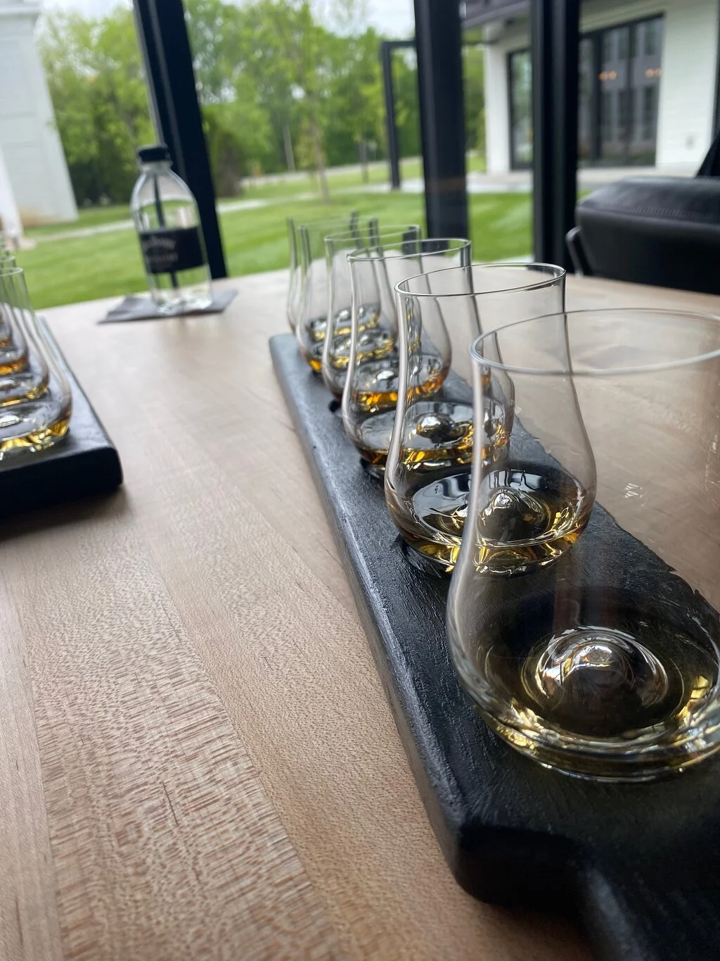 Six glencairn whiskey glasses lined up for a whiskey tasting at the Jack Daniel Distillery in Lynchburg, TN.