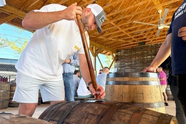 Corporate group pulling whiskey directly from a barrel during a private Nashville distillery experience