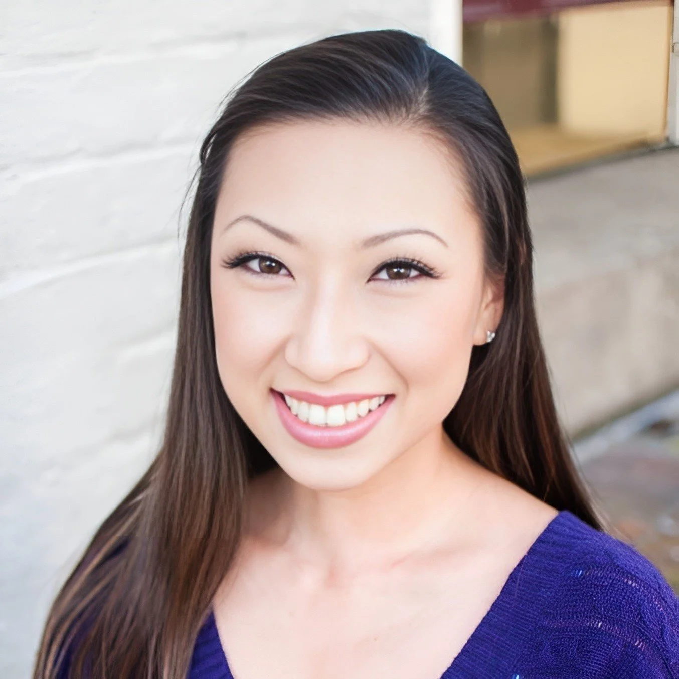 Woman with dark hair smiles at camera