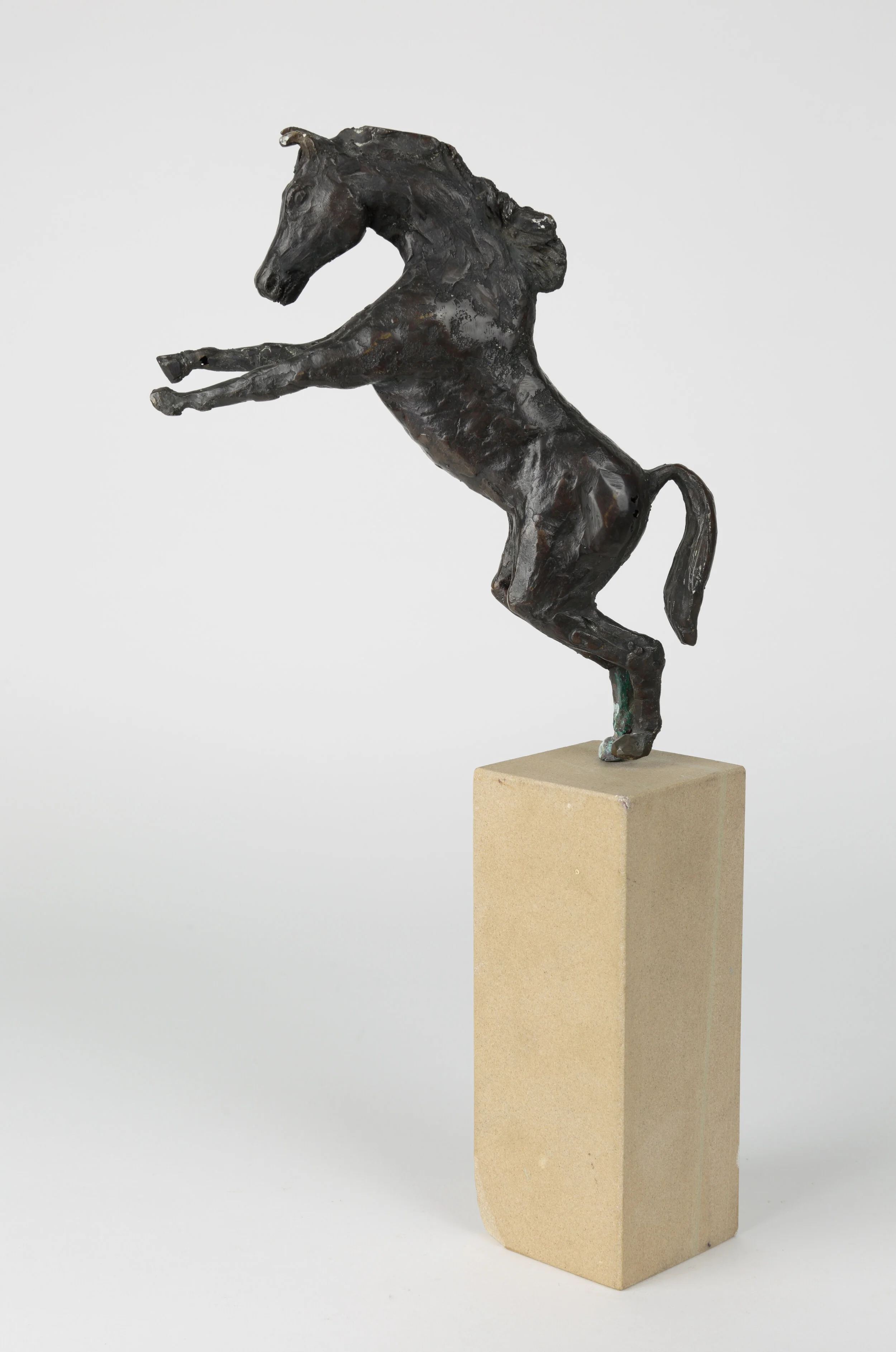 Bronze sculpture of a rearing horse standing on its hind legs, fixed to a sandstone plinth, by Jan Alexander.