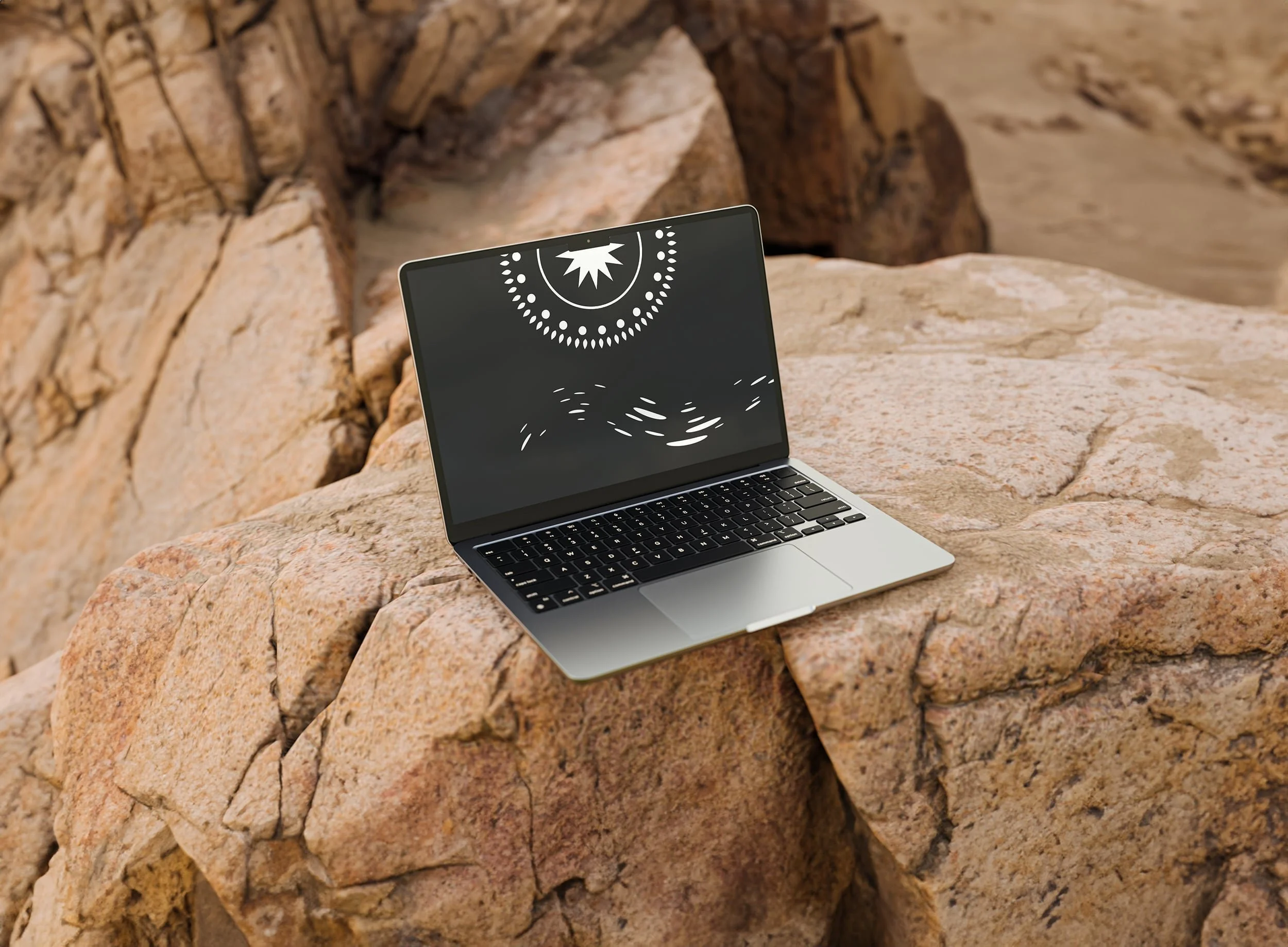 Laptop on rocky surface with artistic screen display, outdoors