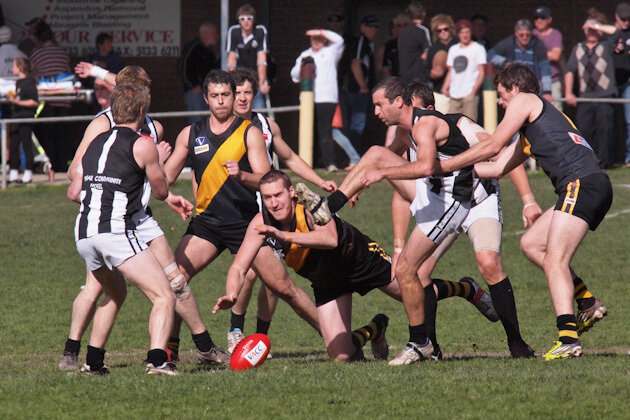 Player from the Mirboo North Tigers attempting to grab the ball in a game of AFL.jpg