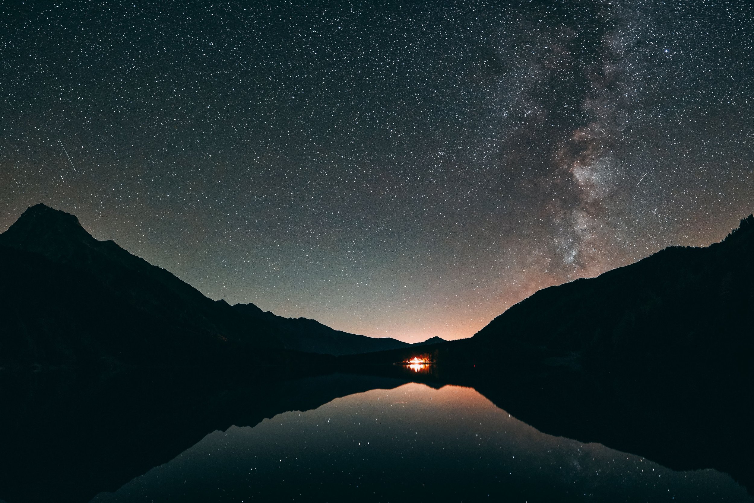 Night sky with fire burning in valley below, visualizing stress and its relationship to sleep disruption and insomnia.