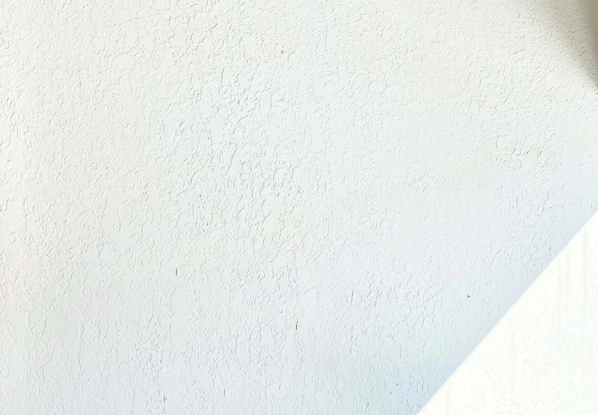 Rough wall with shadow and glimpse of light in lower corner Andrew Wilton LCSW, depression therapist's office near Buffalo in Western New York