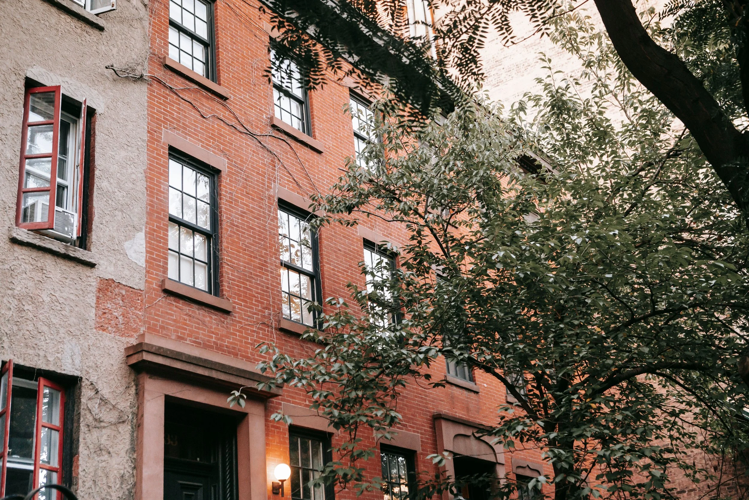 New York brick residential building with trees at dusk, reflecting the structure and calmness in therapy for anxiety