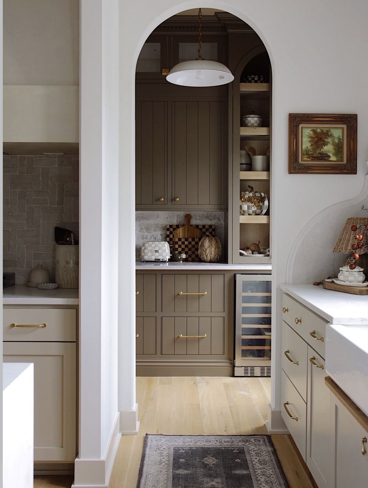 Open-plan Vancouver kitchen renovation with two-tone cabinetry and integrated scullery door, natural light from west-facing windows