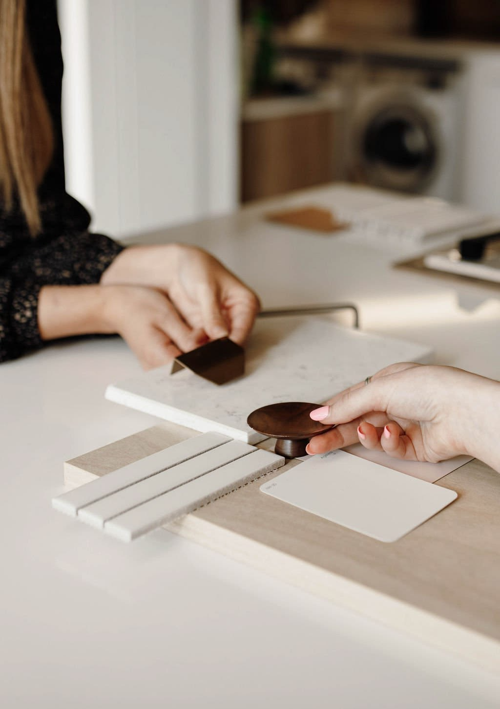 Designer reviewing kitchen elevations and finish samples on a table in a Vancouver home