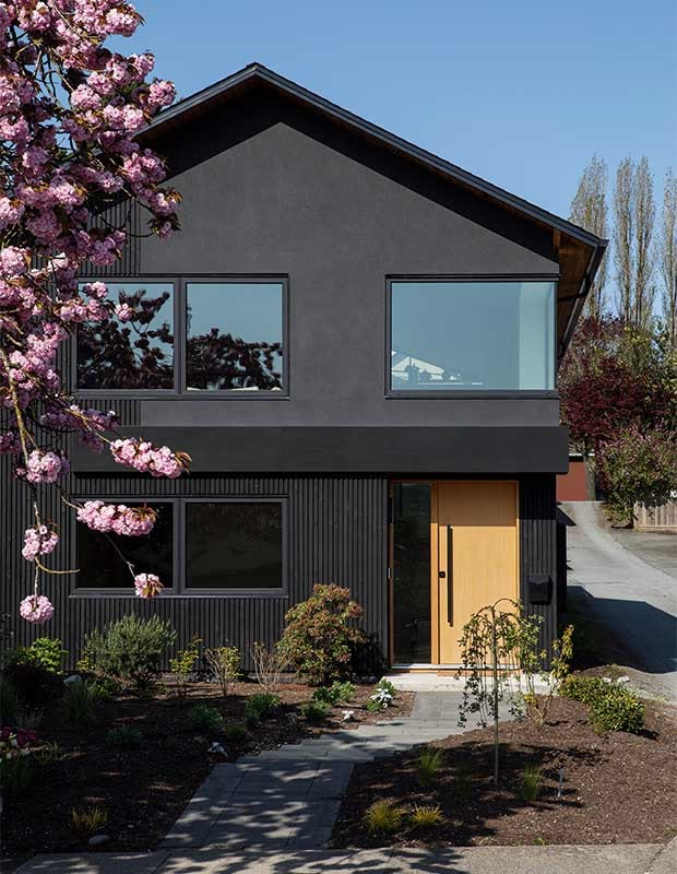Classic Vancouver Special house exterior with brick lower floor and full-width upper balcony