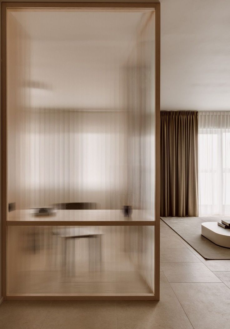 Broken floor plan living space in a Vancouver home with glass partition between kitchen and lounge