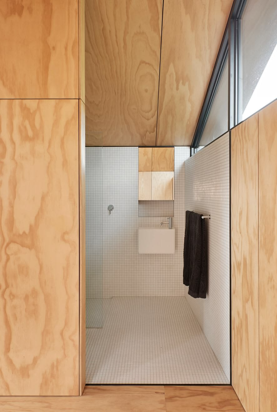 West Coast Modern material palette for laneway house — white oak, matte cabinetry, and stone tile