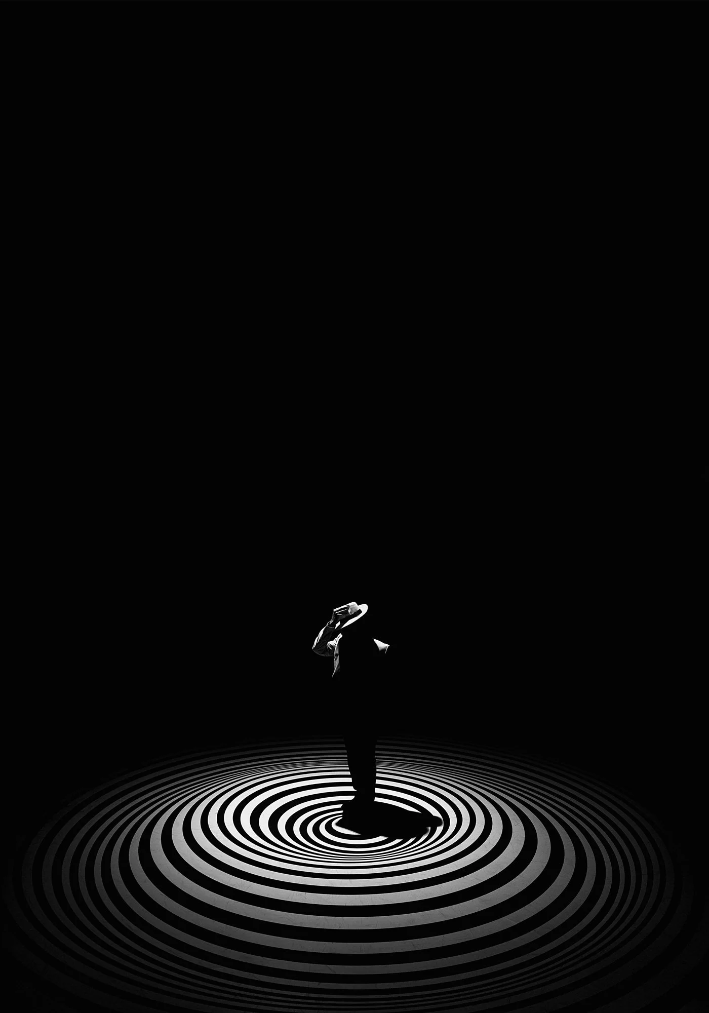 A person wearing a hat, visible only in silhouette, standing on a circular pattern on the floor in a dark room.