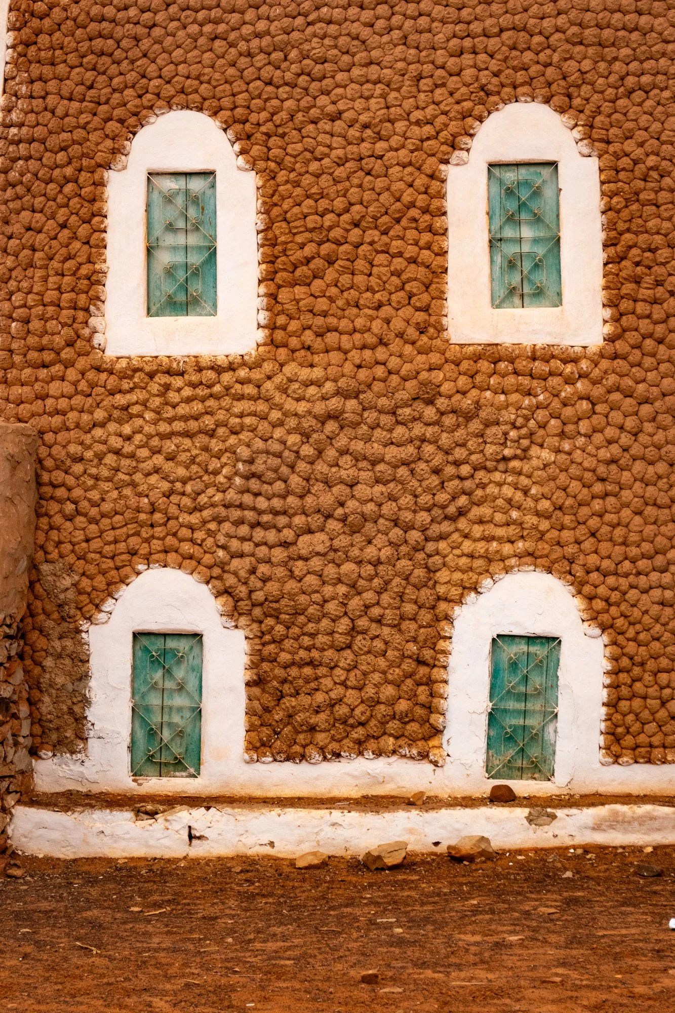 Architectural detail.  The uneven nature of the render casts shadows, keeping the wall a bit cooler.
