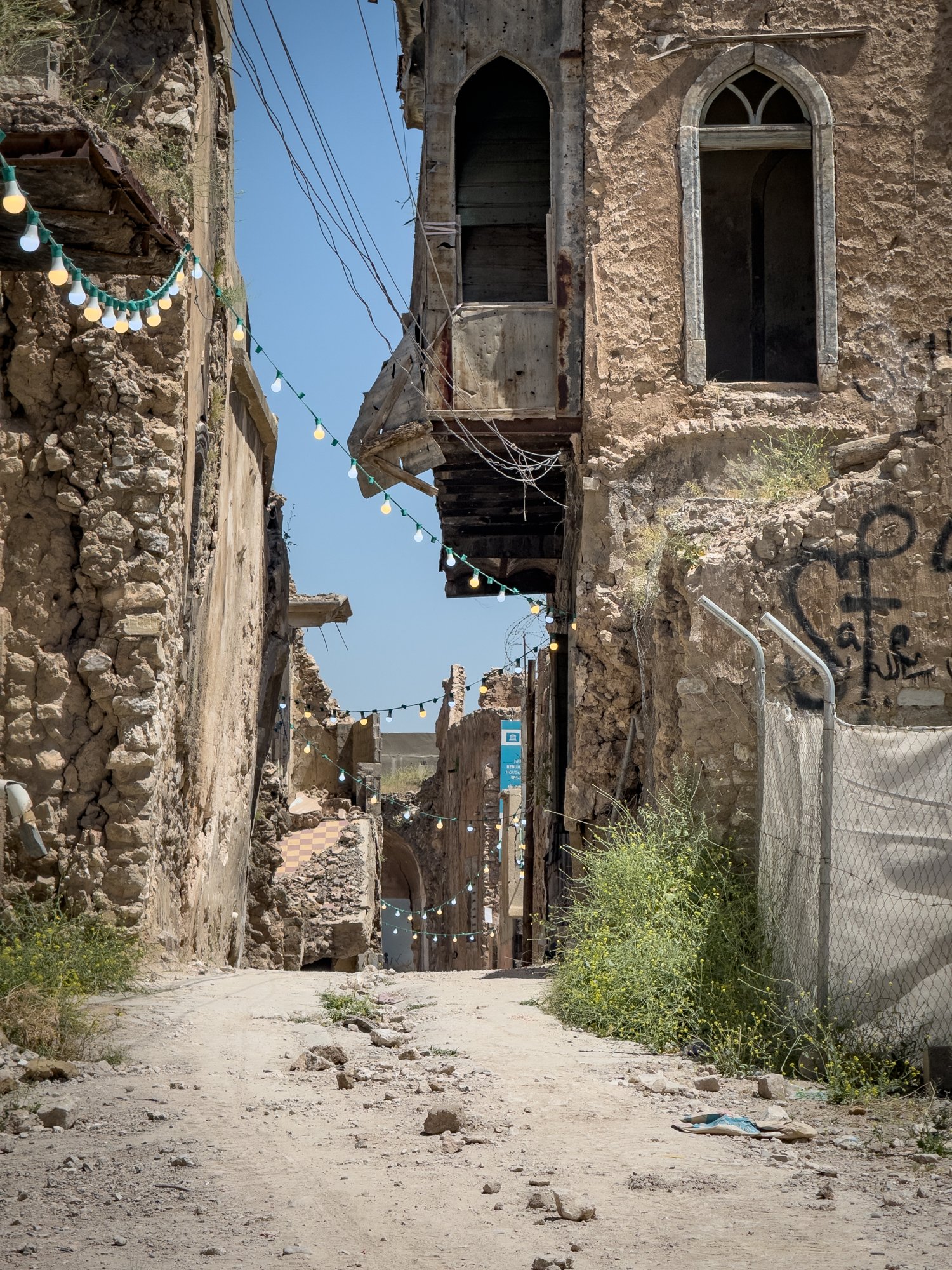Alleyways through Old Mosul. Strings of streetlights are hung to provide light at night for the few remaining inhabitants following the destruction by ISIS which ended in 2017.