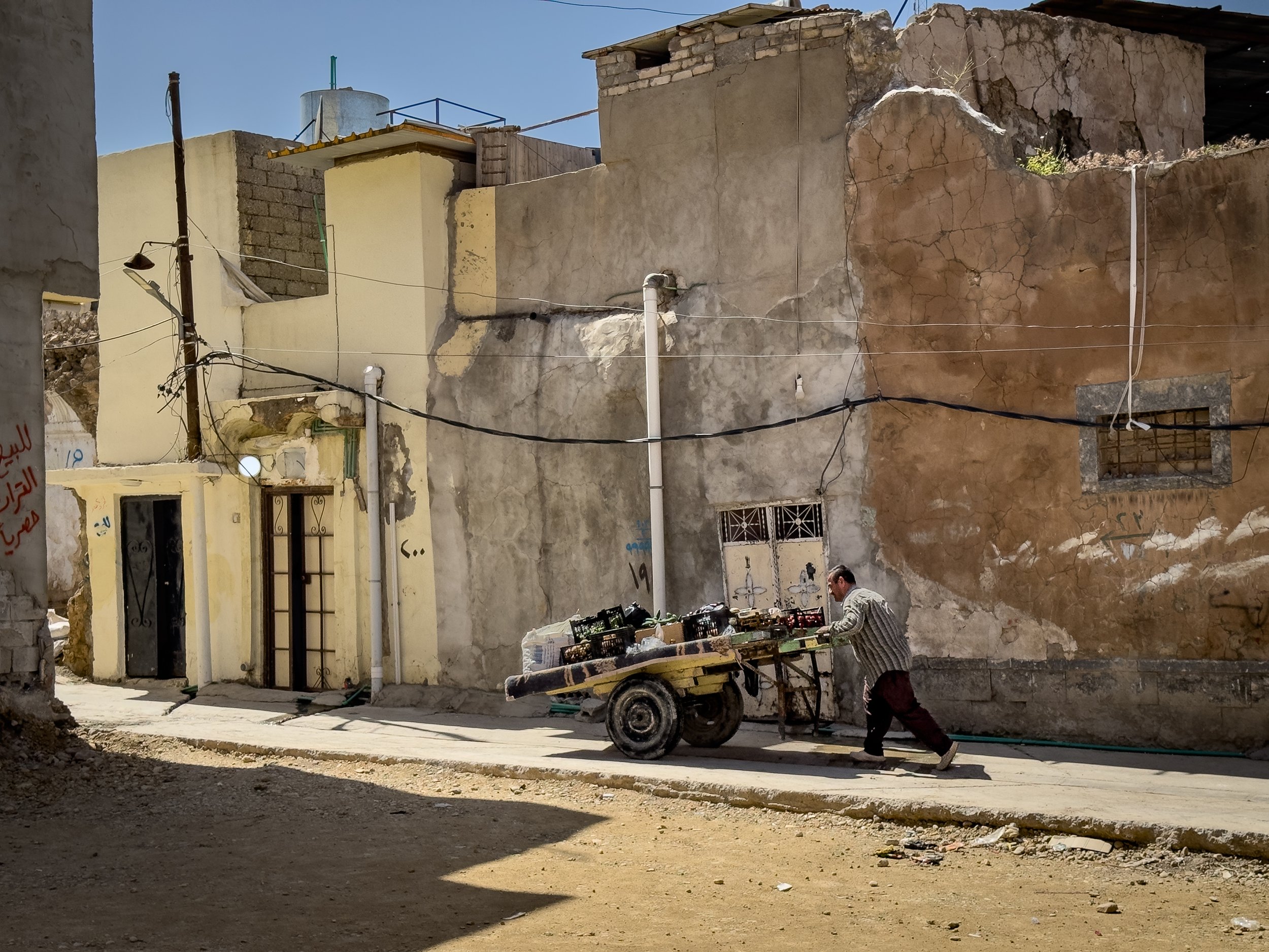 A Vendor selling vegetables in Old Mosul.