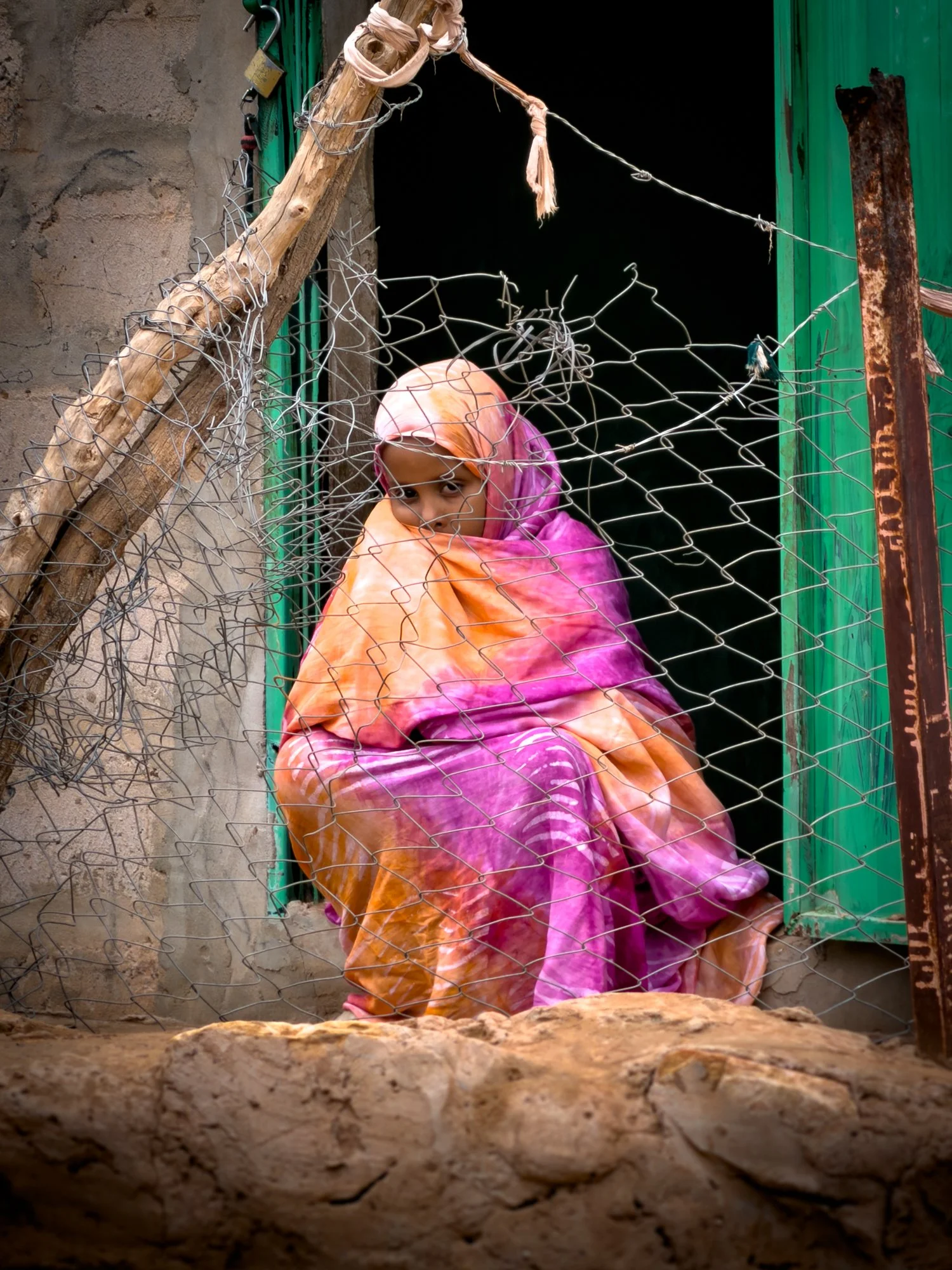 A young girl sitting in a shop doorway