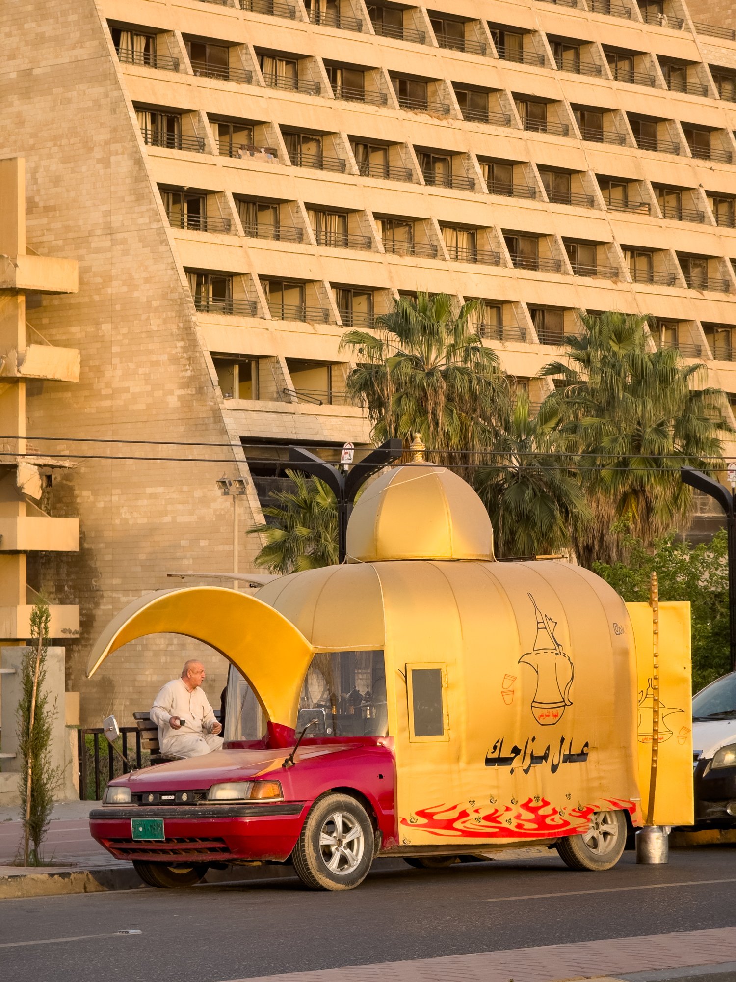 A Coffee Van in front of a ruined 5* Hotel from the Sadaam era.