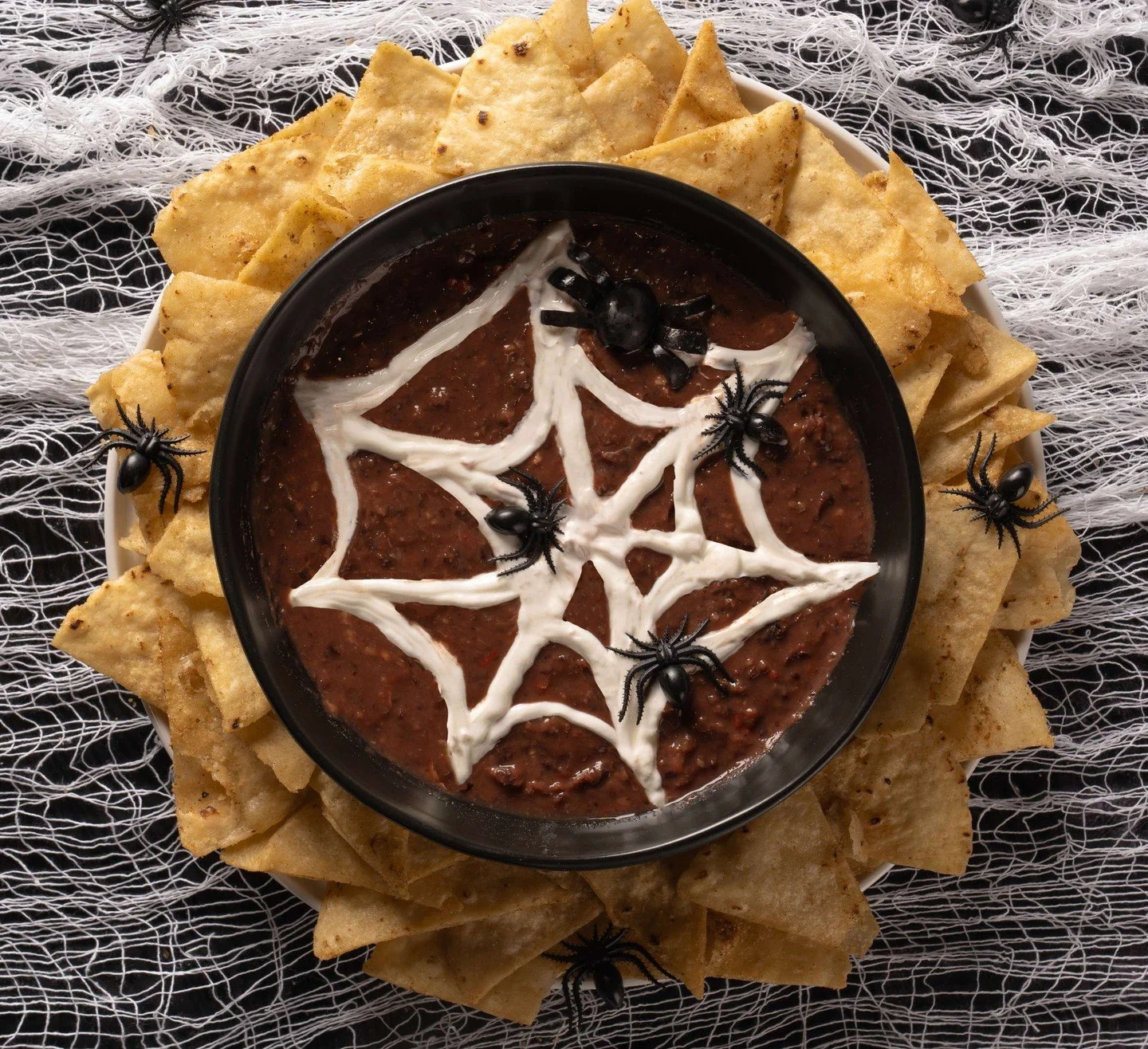 Snack goals for spooky season. 🖤 Black bean dip + sour cream spider web + Ava&rsquo;s Grilled Crisps = Halloween perfection.

Get the recipe ⬇️

Ingredients:
&bull;  1 can black beans, drained and rinsed
&bull;  1 clove garlic
&bull;  1 tbsp lime ju