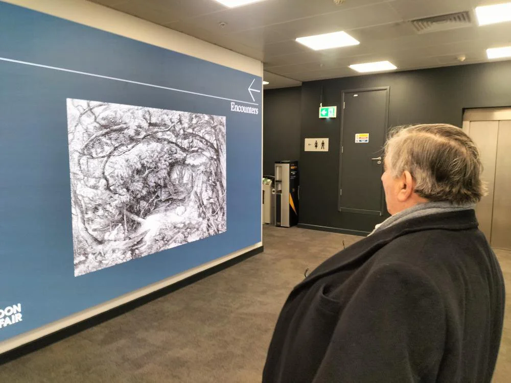 Jolyon Drury with his fathers etching on show as you walk in to the fair.