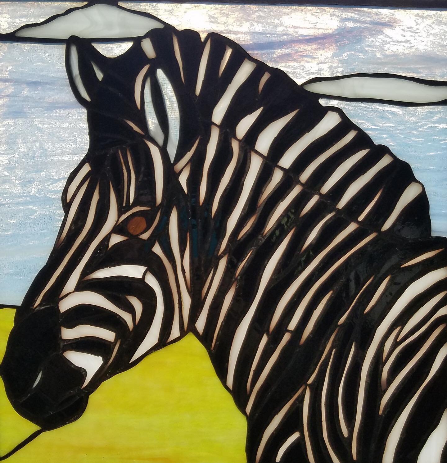 Member and glass artist Meg Zellinger
created this stained glass panel based on a zebra she photographed while in Botswana. Meg points out that stained glass looks different as the light changes. When viewed at night, she says, light from the room ch
