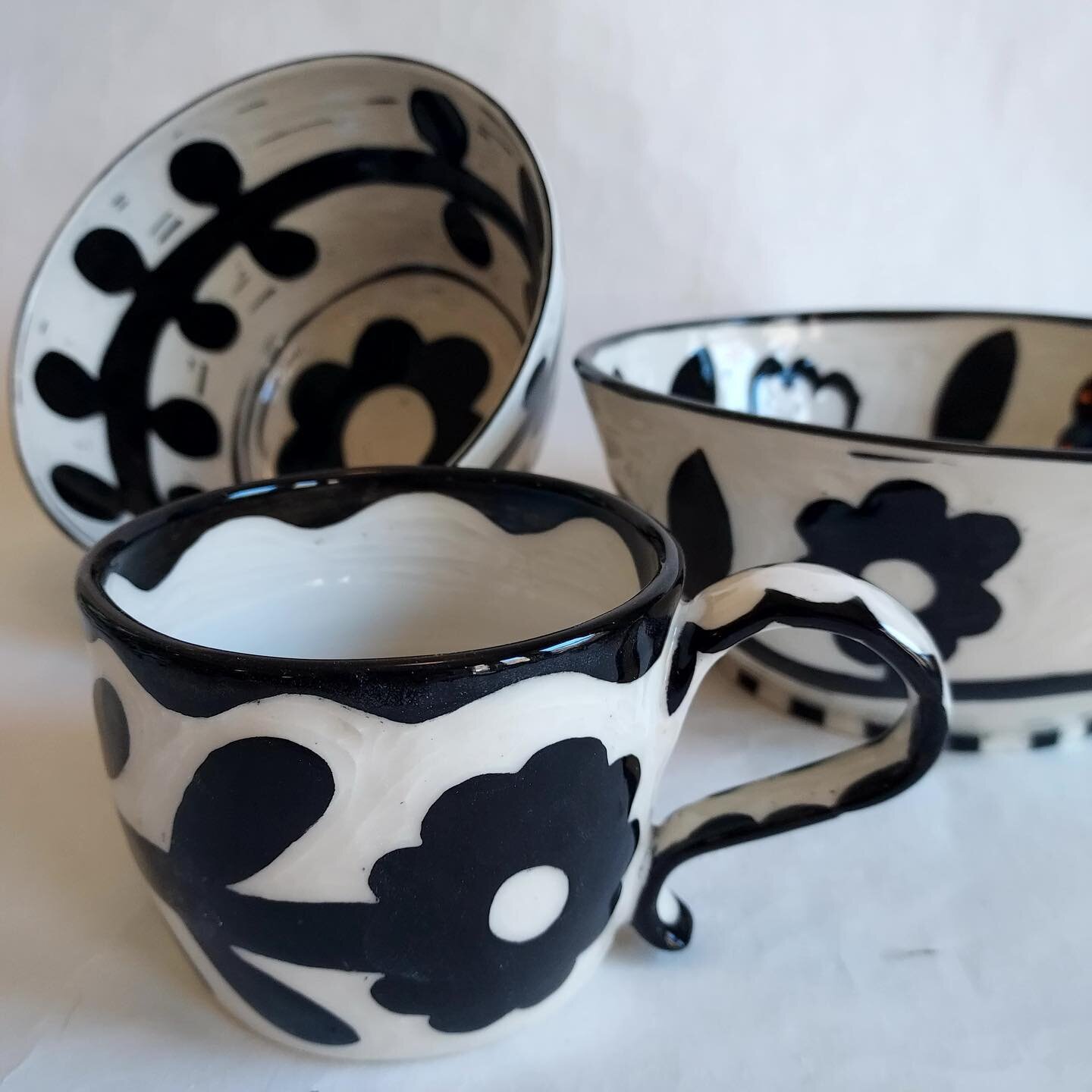 Sara Cox been creating work as @delilahpottery for over 30 years. This season she is focusing on making black and white pottery using the sgraffito technique. She applies black underglaze to leather hard wares, and carves images onto them, exposing t