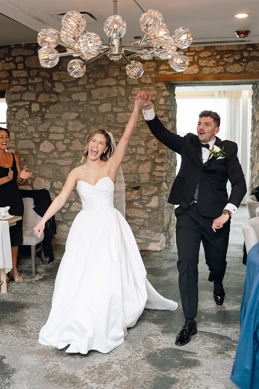 Newlywed couple smiling candidly during their grand entrance at an Ontario wedding reception