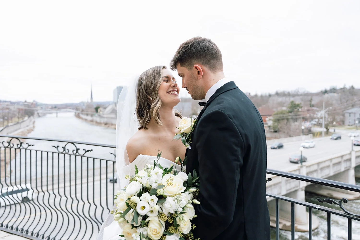 Bride and groom giggling together during natural wedding portraits in Ontario