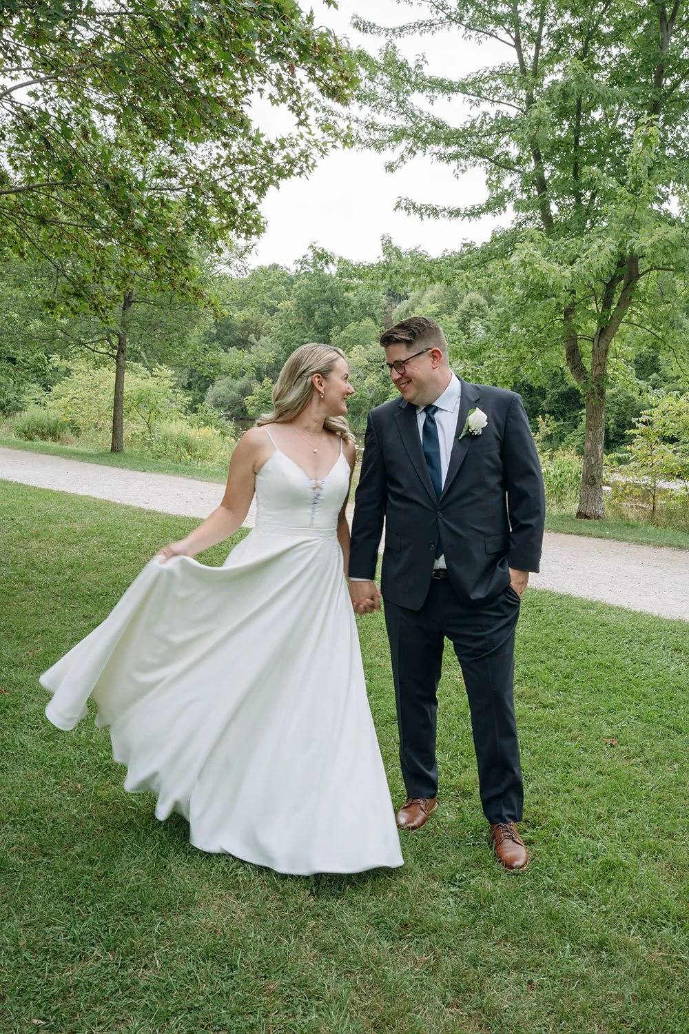 Bride and groom portraits in a Toronto park with bride swinging her wedding dress
