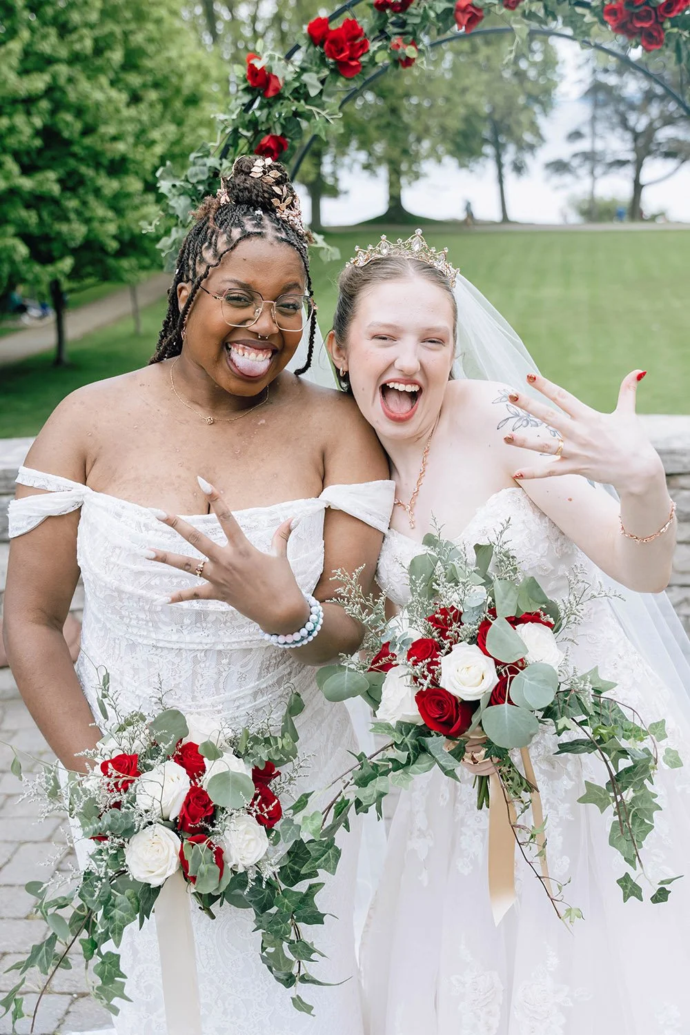 Two brides proudly showing their wedding rings to the camera after getting married in Ontario, captured by a documentary-style wedding photographer.