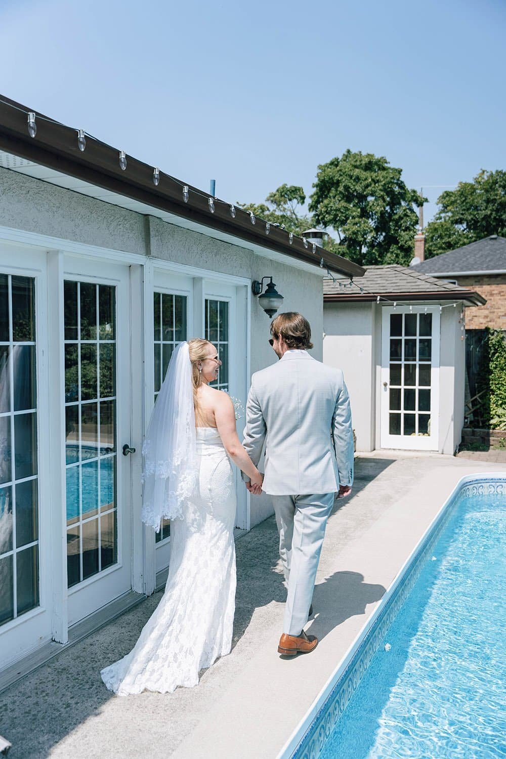 Couple walking hand in hand through a backyard during documentary-style Ontario wedding photography