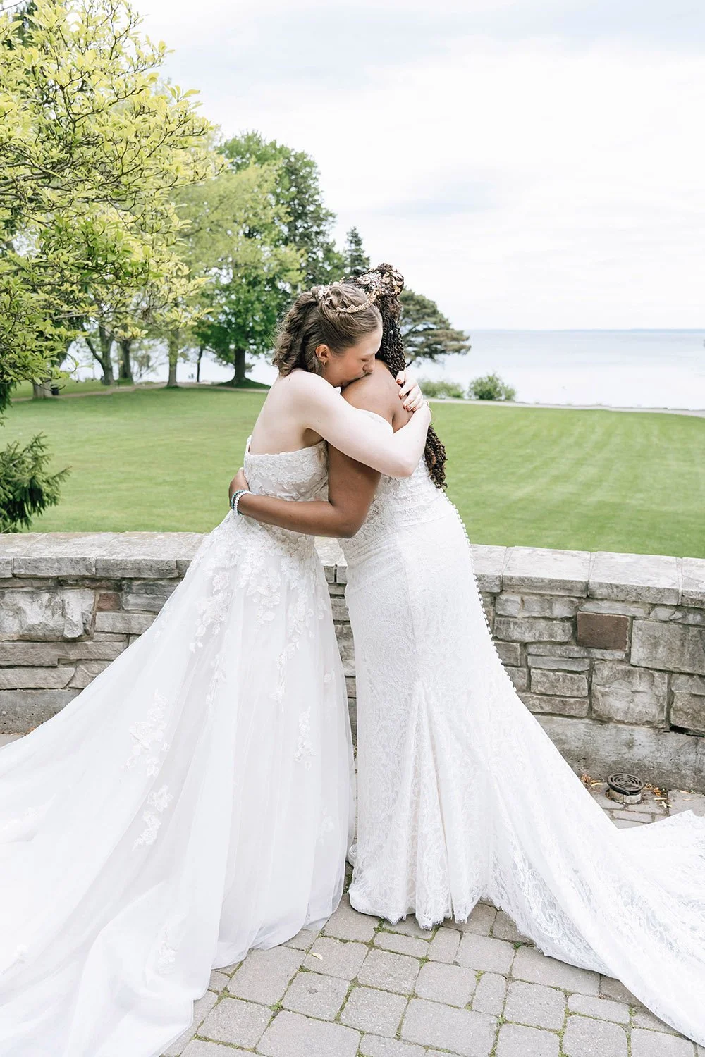 Two brides embracing during an emotional first look at their Ontario wedding