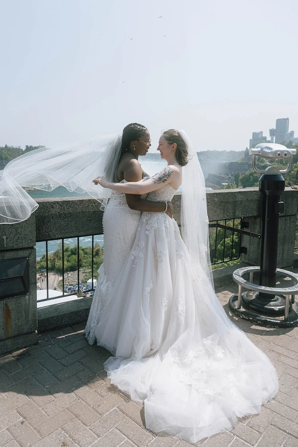 LGBTQ+ couple embracing at Niagara Falls during documentary-style couples photography