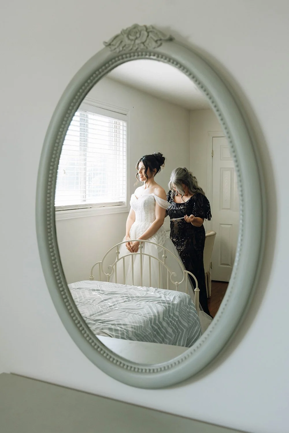 Mother helping her daughter get dressed before her Hamilton, Ontario wedding ceremony