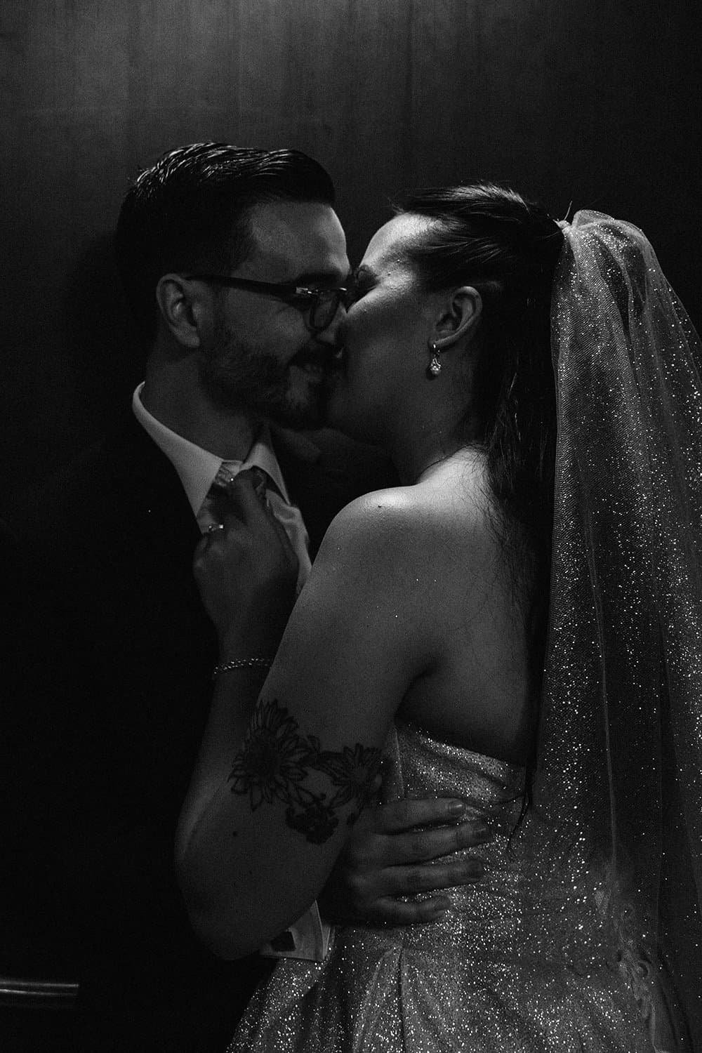 Couple embracing and kissing in an elevator during candid wedding photography in Toronto