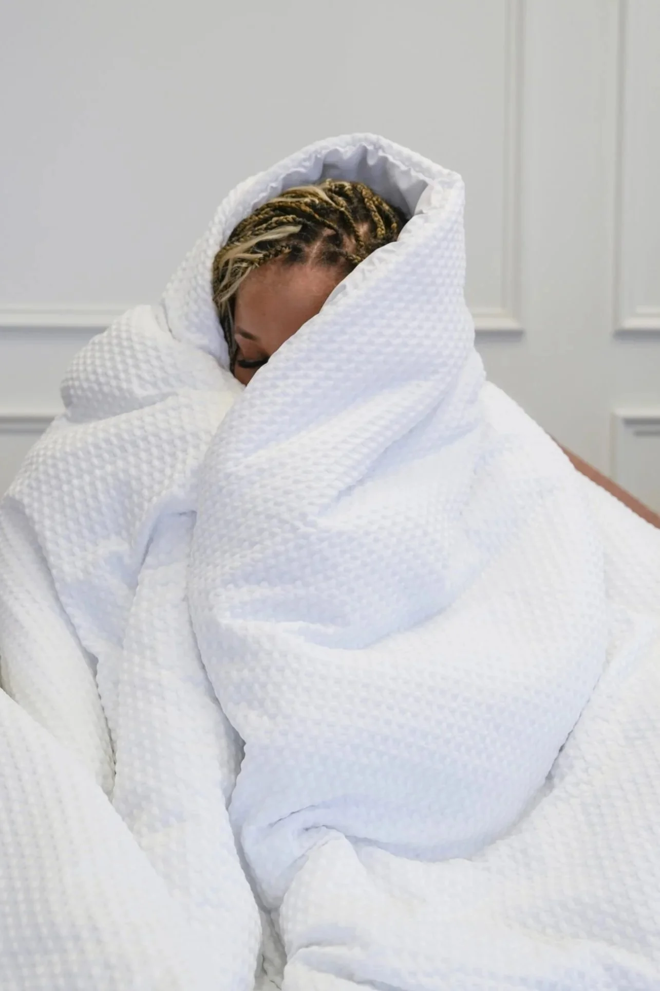 scared woman hiding under a blanket
