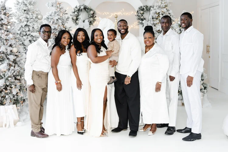 Nine family members across three generations, dressed in white.