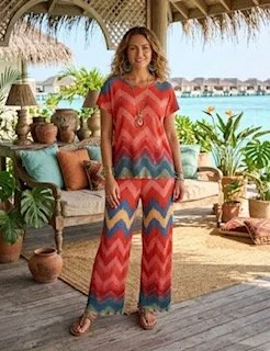 Woman with dark hair in a beret wearing a breton stripe top and dark trousers