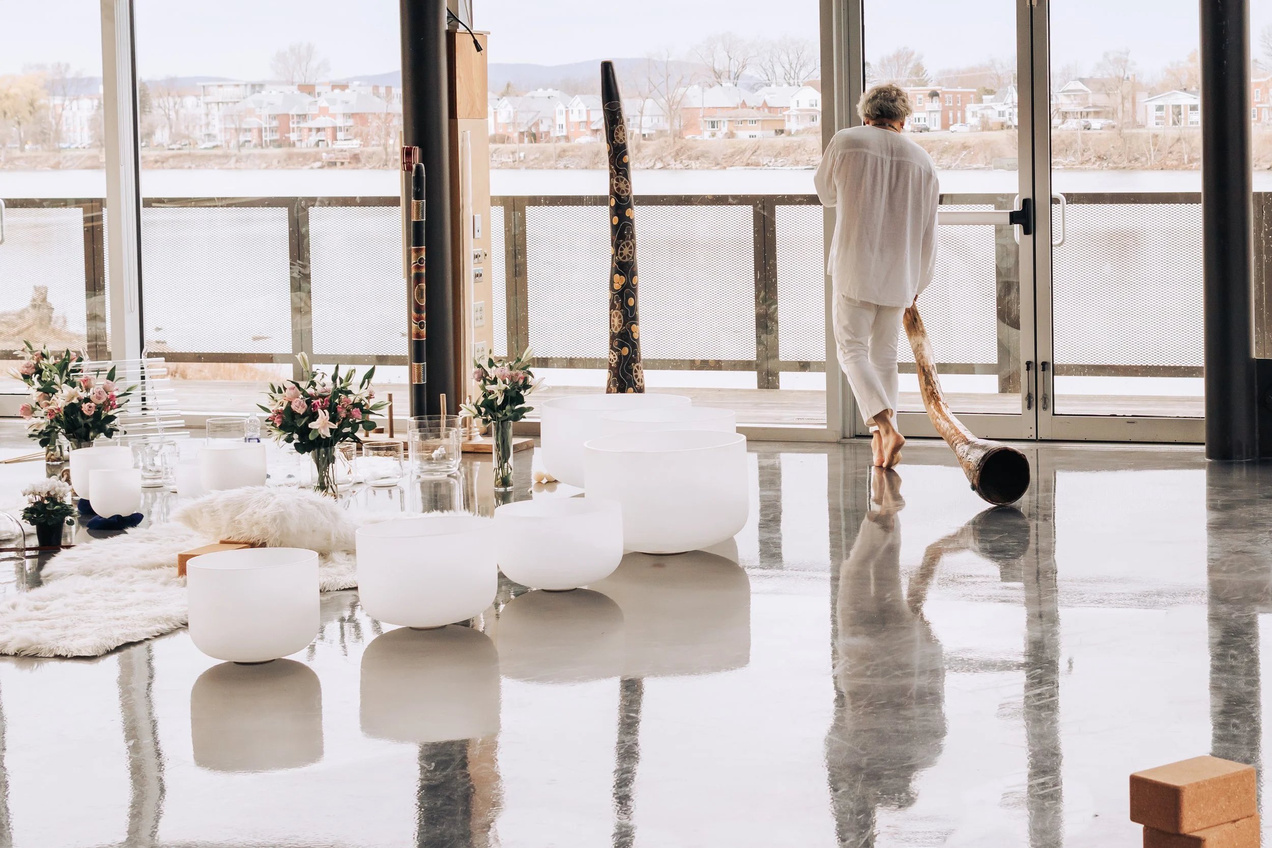 Soin sonore avec didgeridoo et bols de cristal dans un espace intérieur lumineux