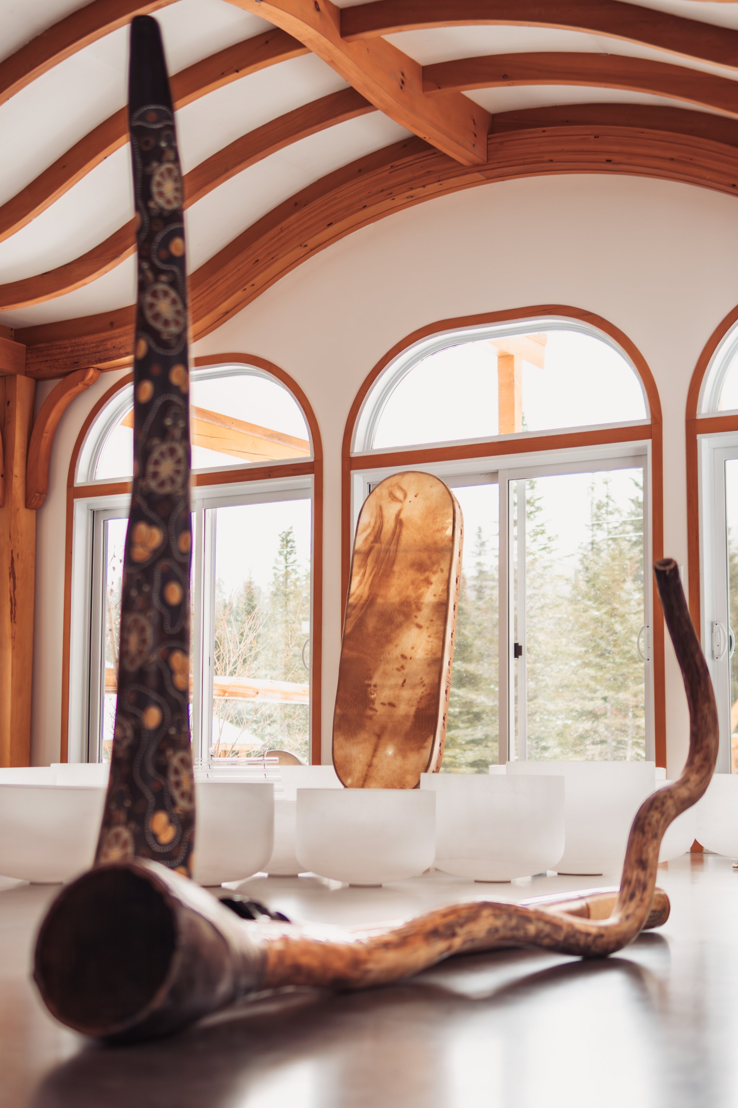 Ensemble de bols de cristal et instruments acoustiques disposés dans une salle de concert lumineuse