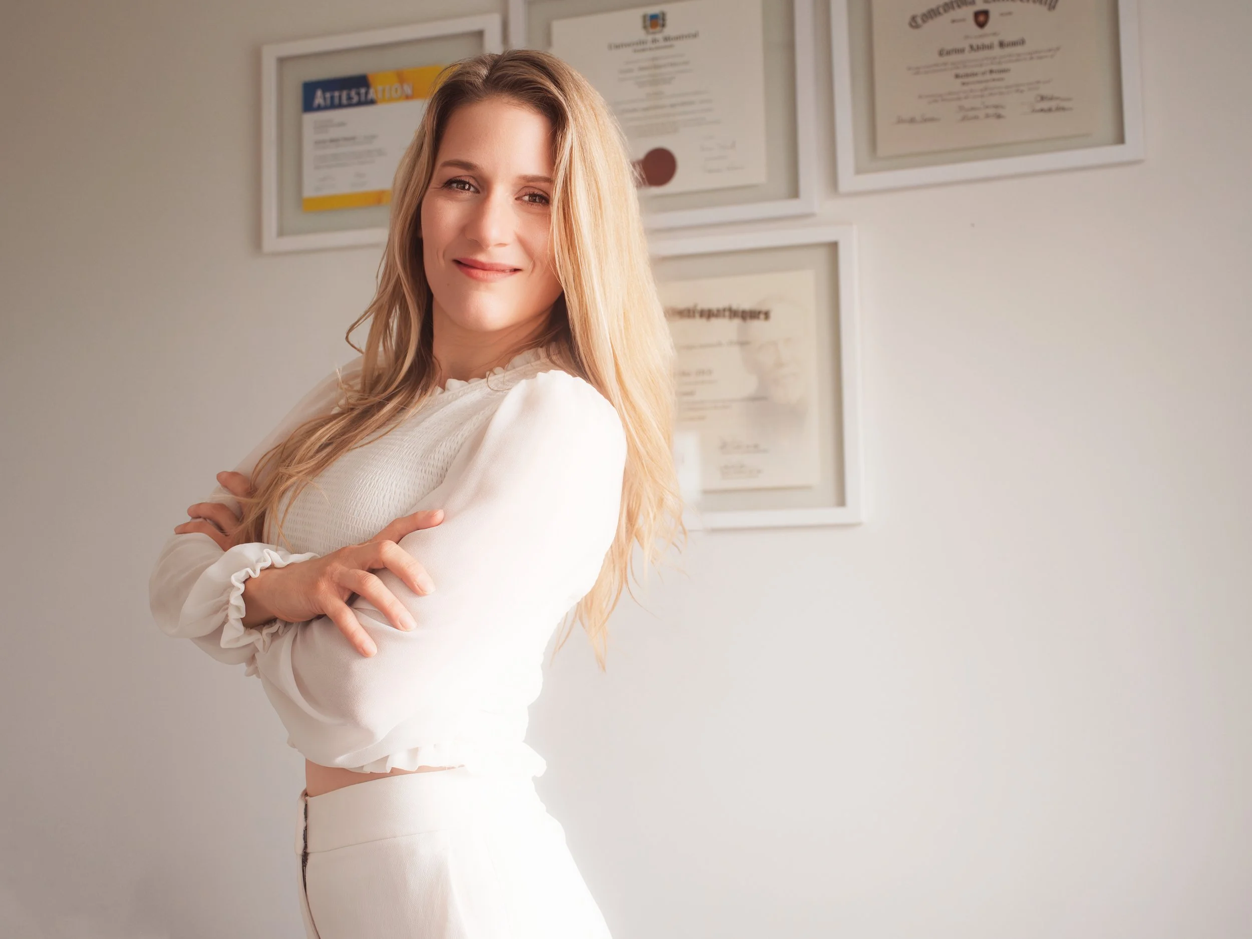 Carine A-Hamid, ostéopathe D.O., devant ses diplômes universitaires à Saint-Hubert.