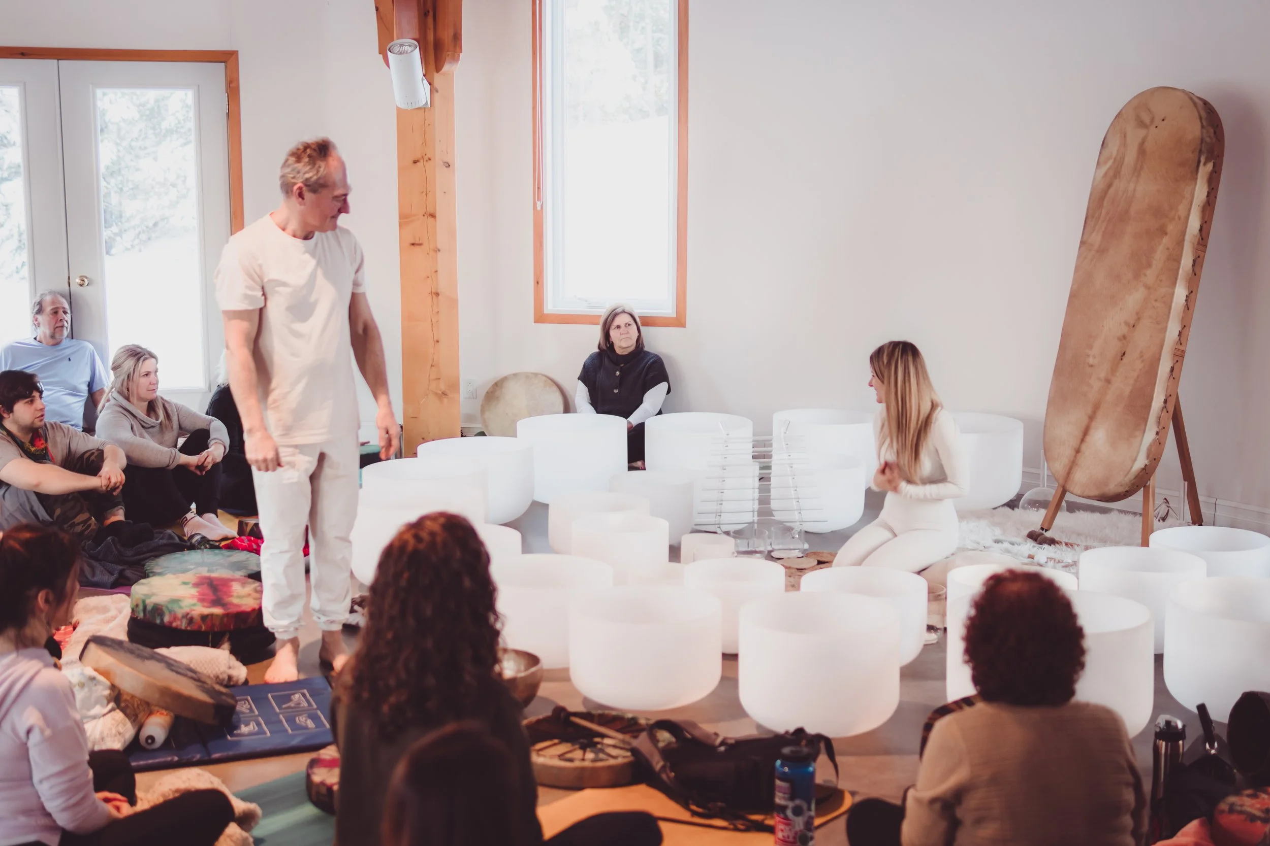 Bain sonore en groupe avec bols de cristal et tambour lors d’une retraite vibratoire