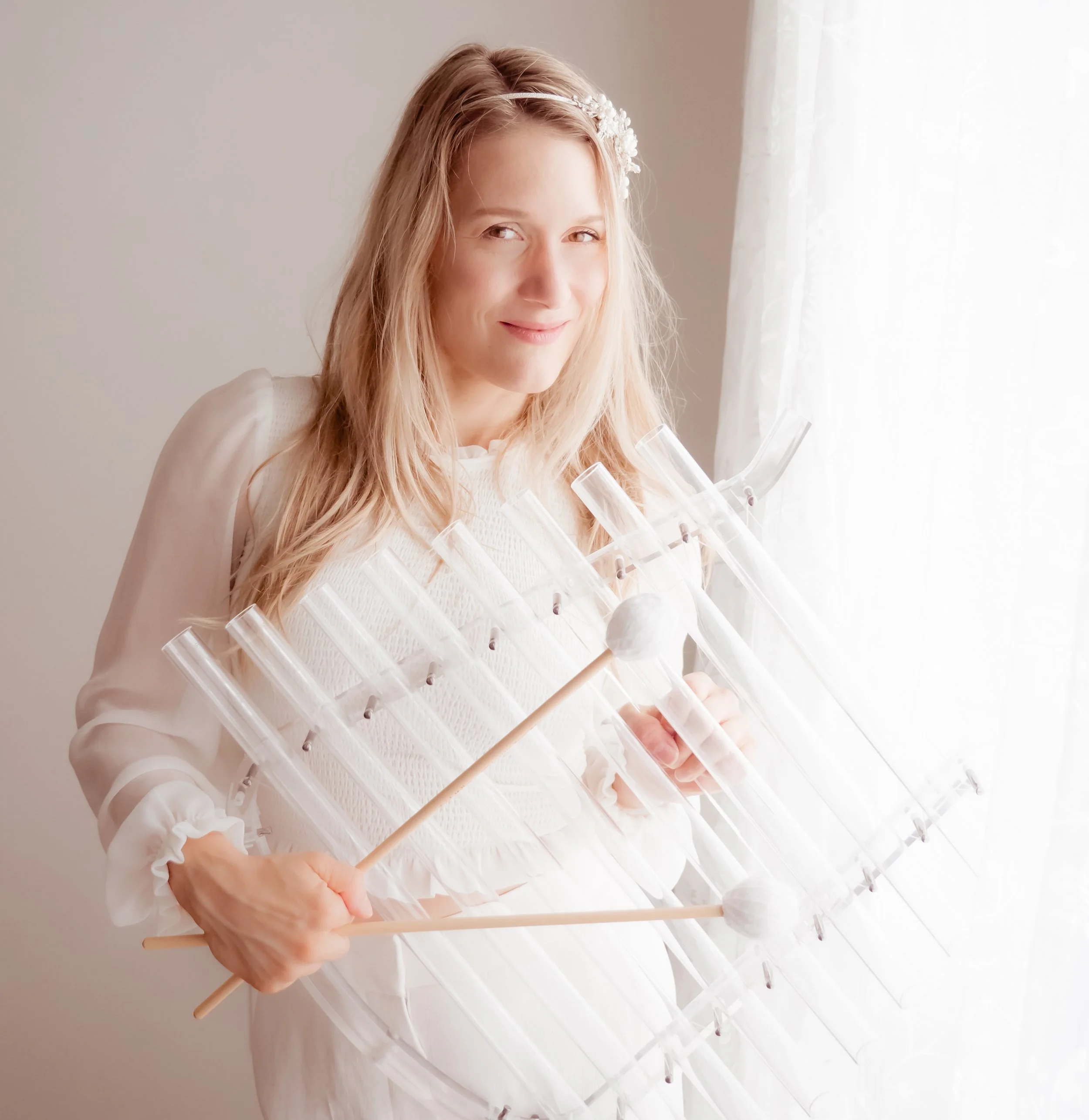 Femme jouant d’un instrument sonore en cristal avec mailloches