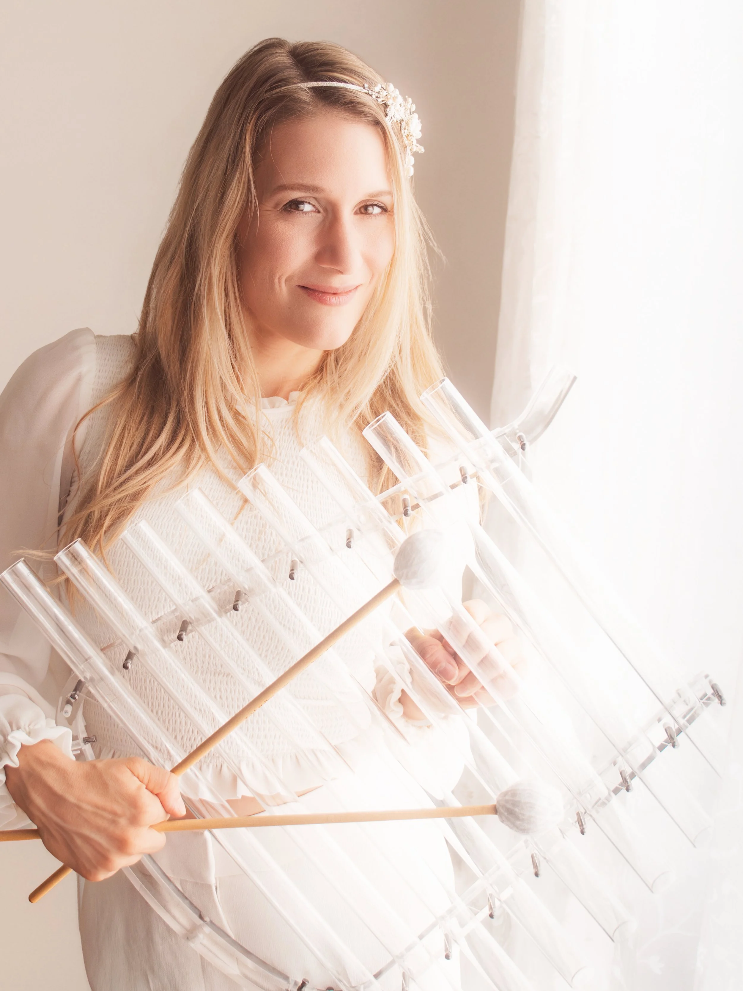Femme jouant d’un instrument sonore en cristal avec mailloches