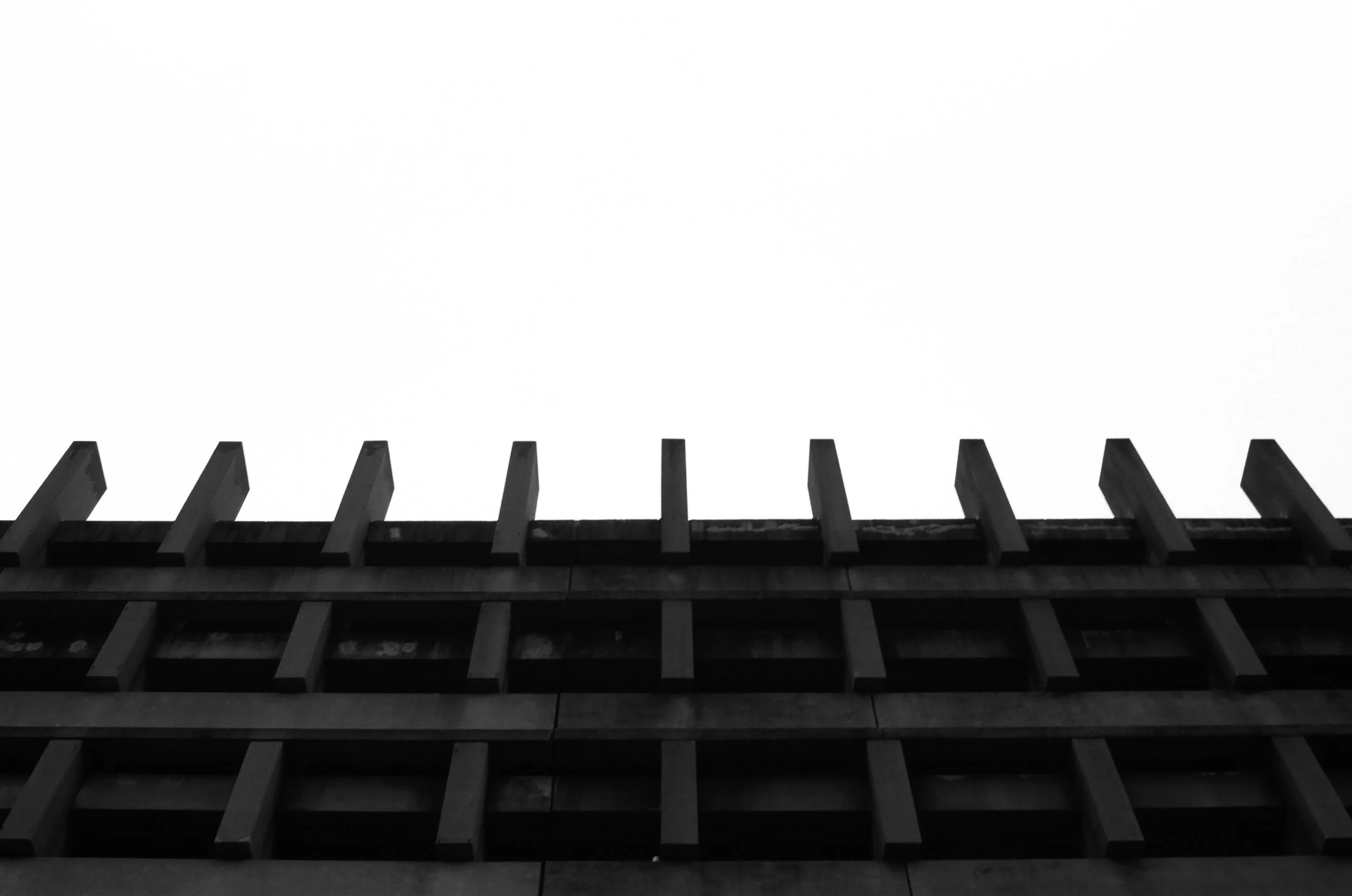   the garage’s brutalist concrete façade pattern extends beyond its top level  