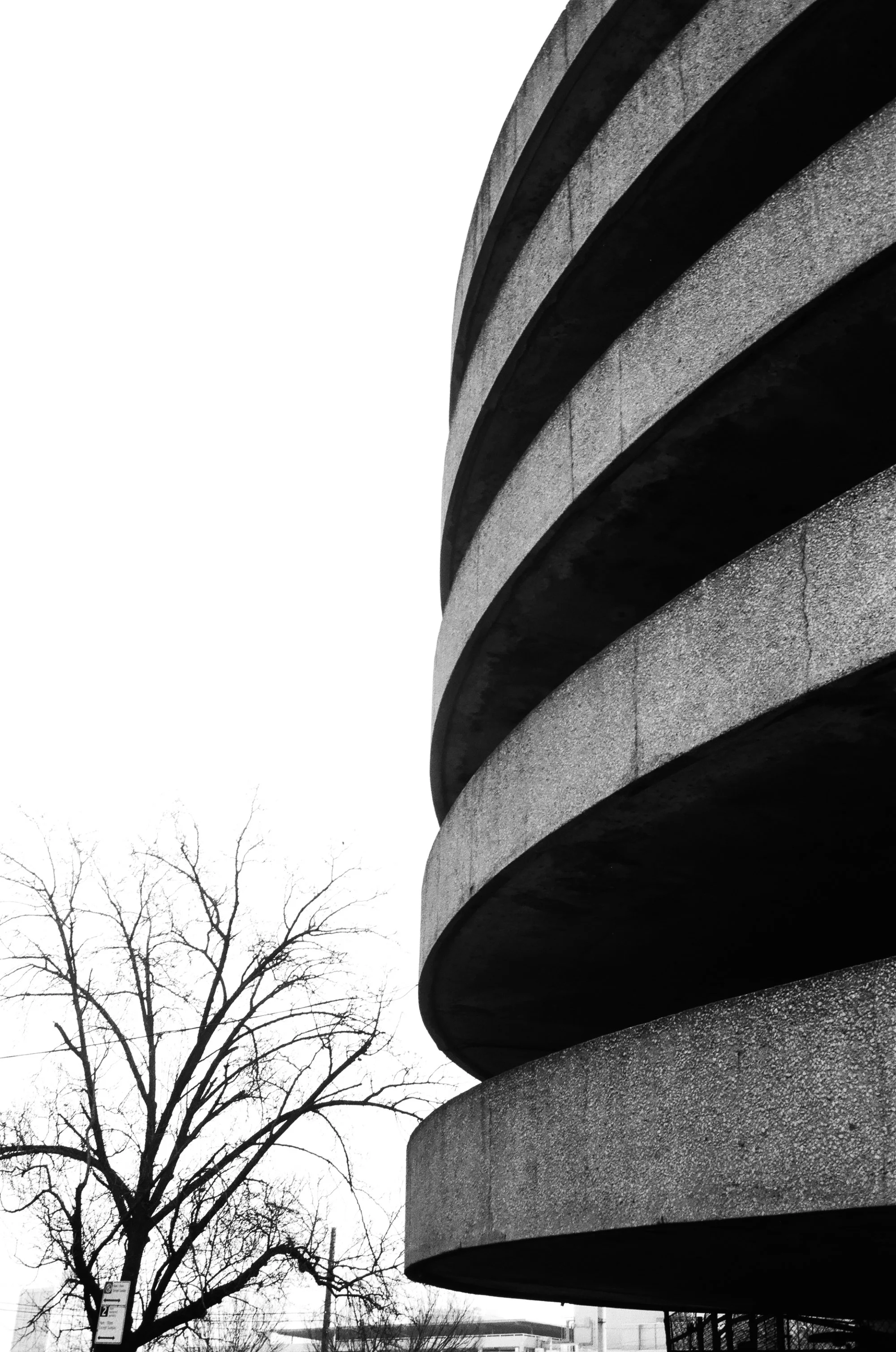   the circular flow of the queens place mall extends unto the parking garage’s entry/exit ramps thanks to their spiral shape  