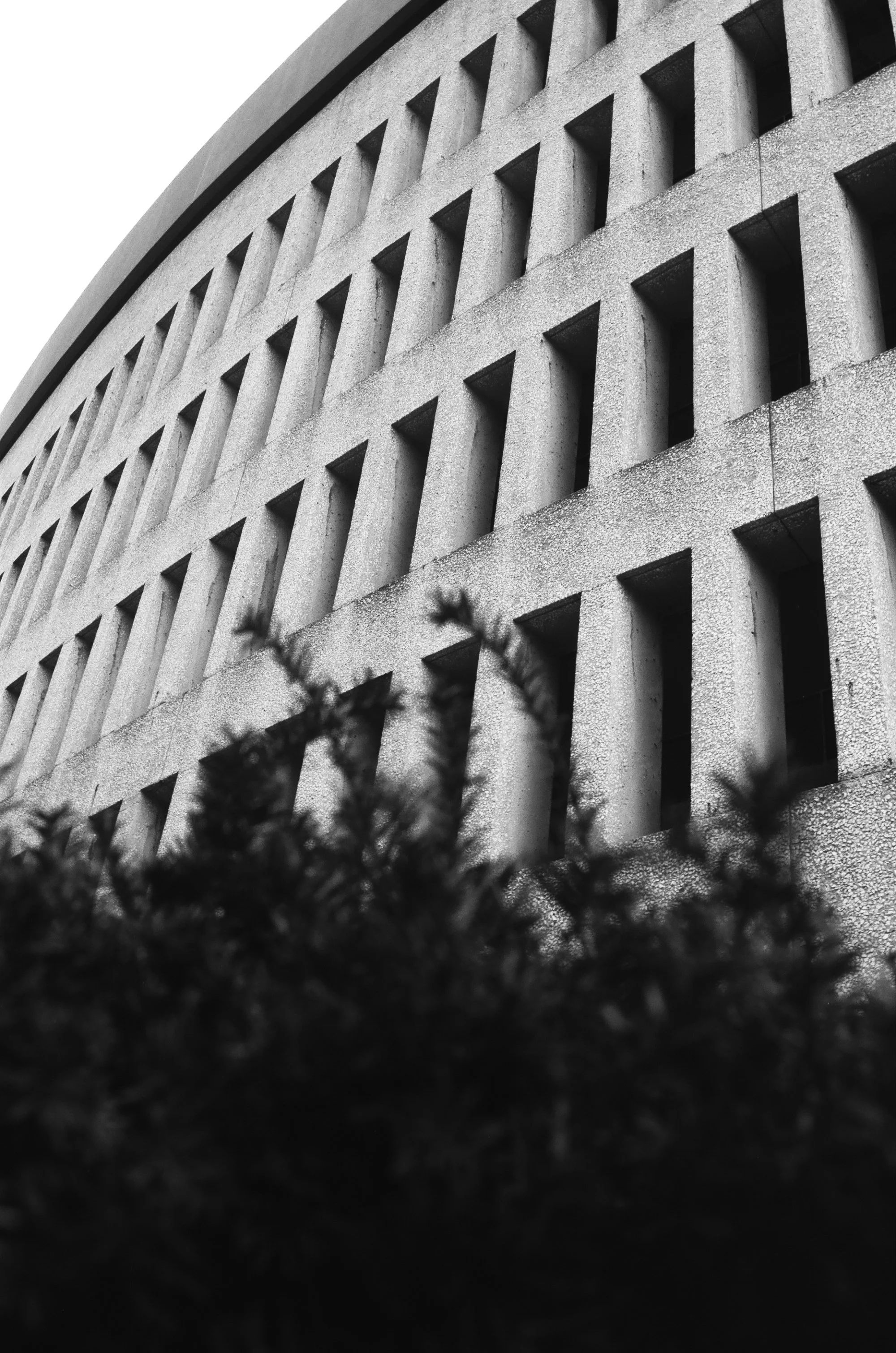   the coarse, sandblasted façade of the mall is broken up by its fenestration  