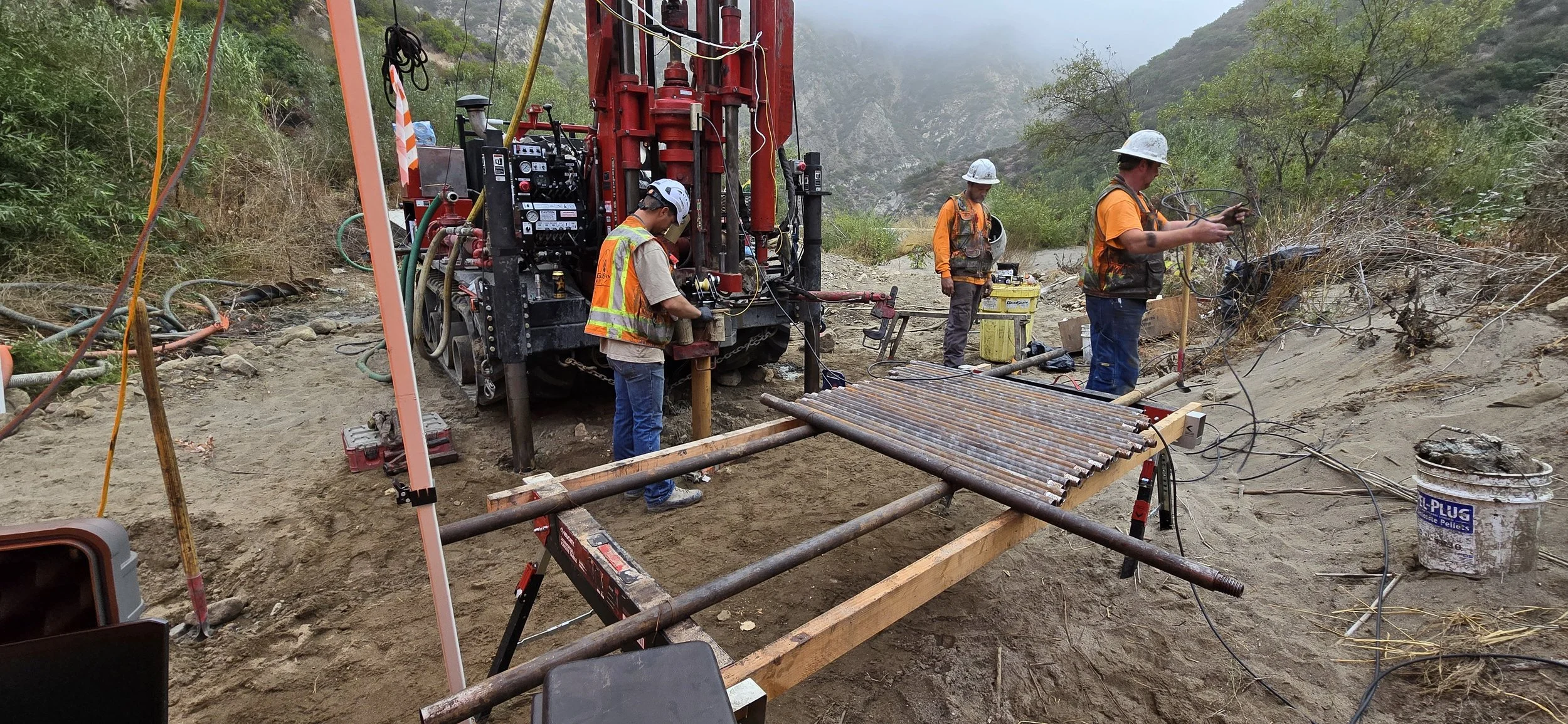 Construction site with workers and drilling equipment in outdoor setting